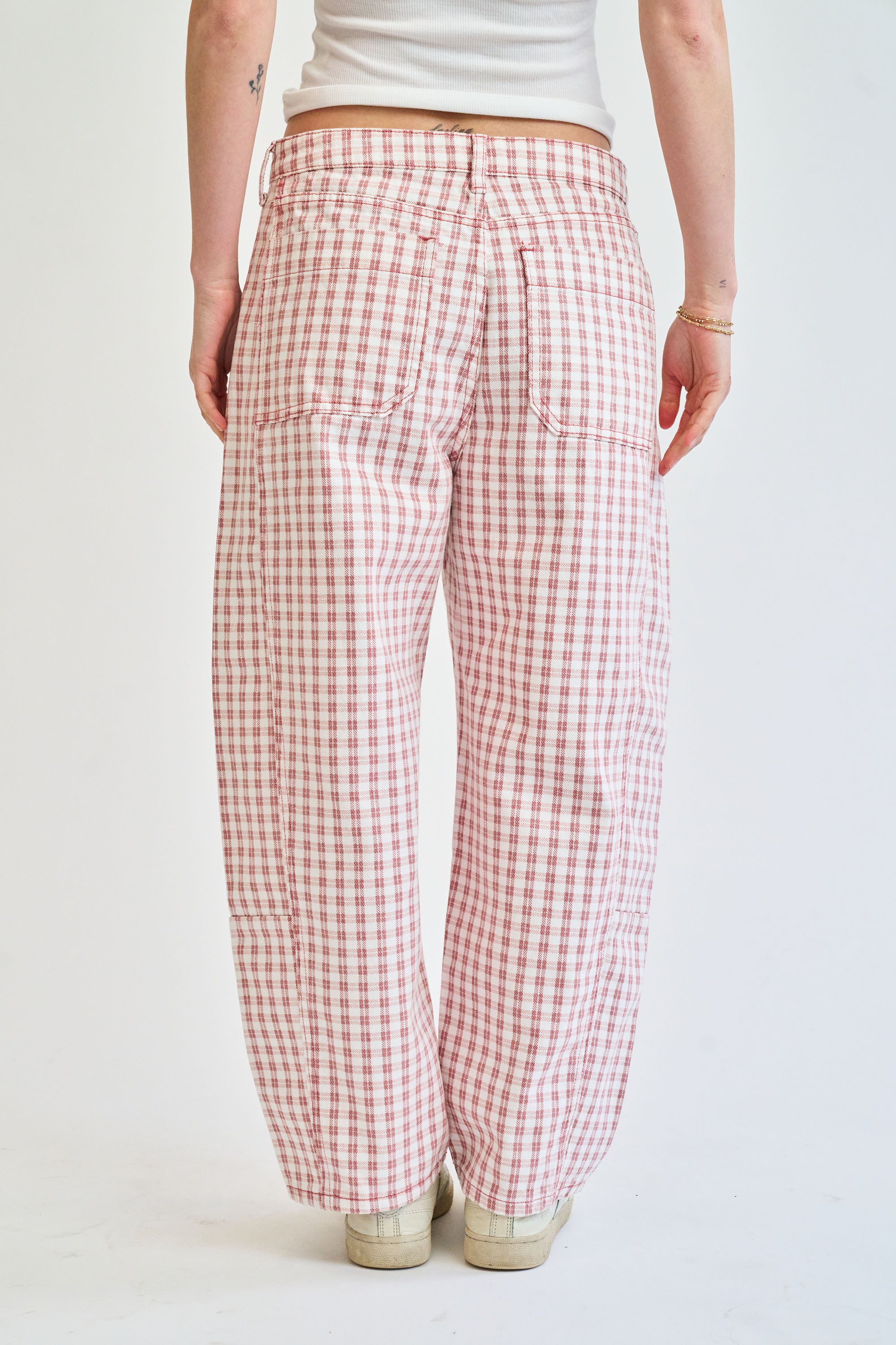 Person wearing red and white checkered pants on a plain background