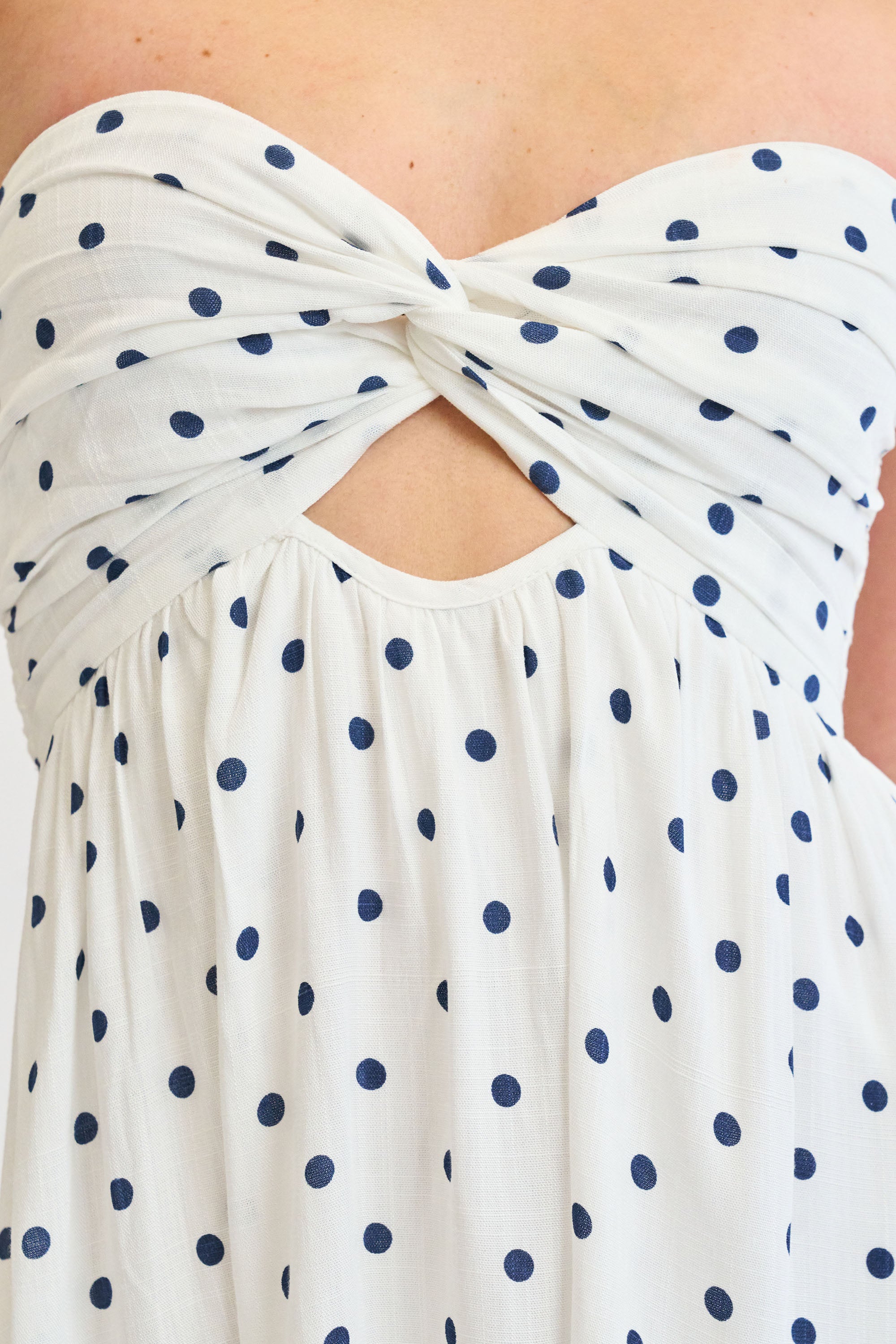 White strapless top with blue polka dots and cutout design.