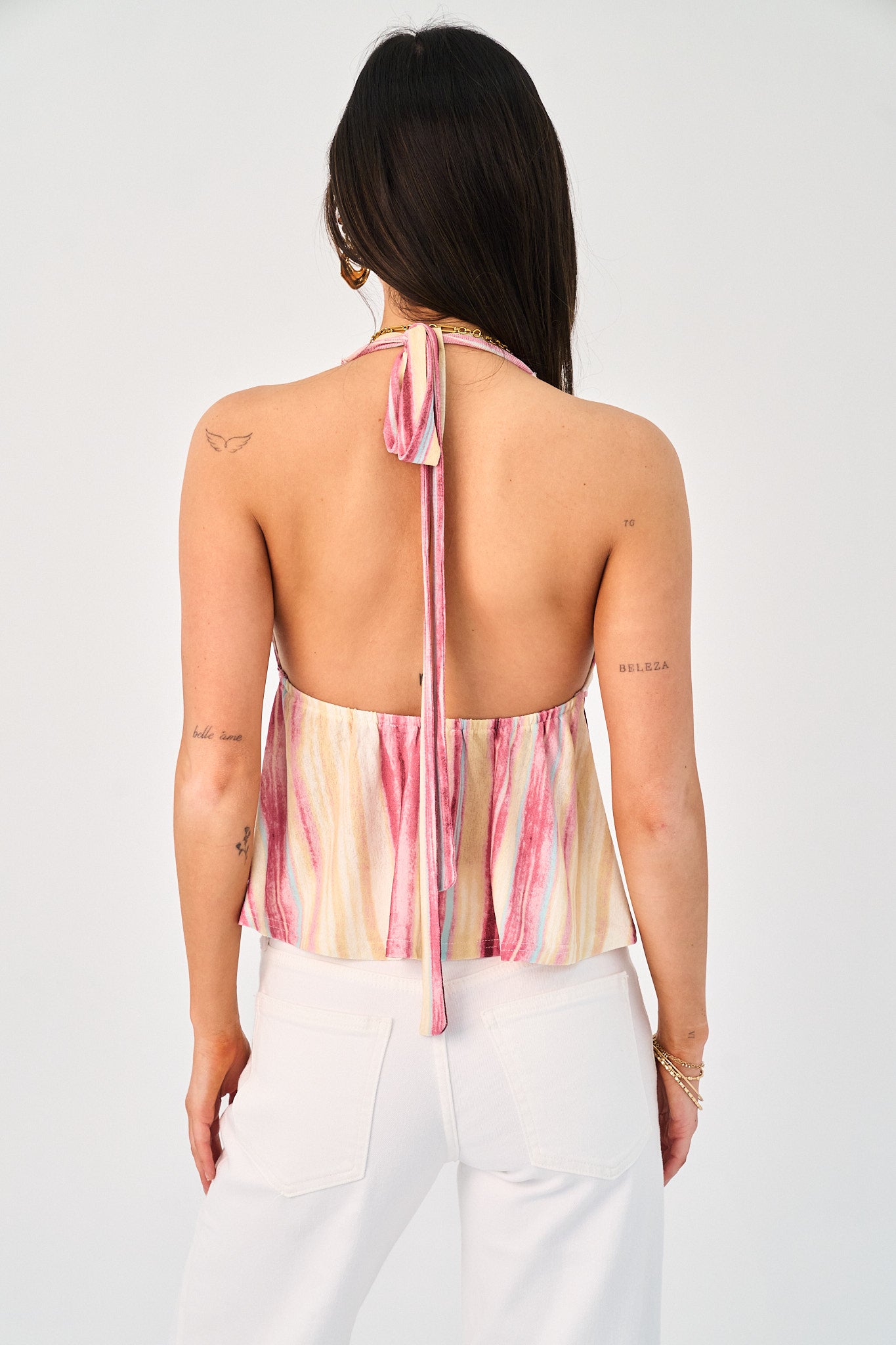 Woman wearing a colorful halter top with a white background