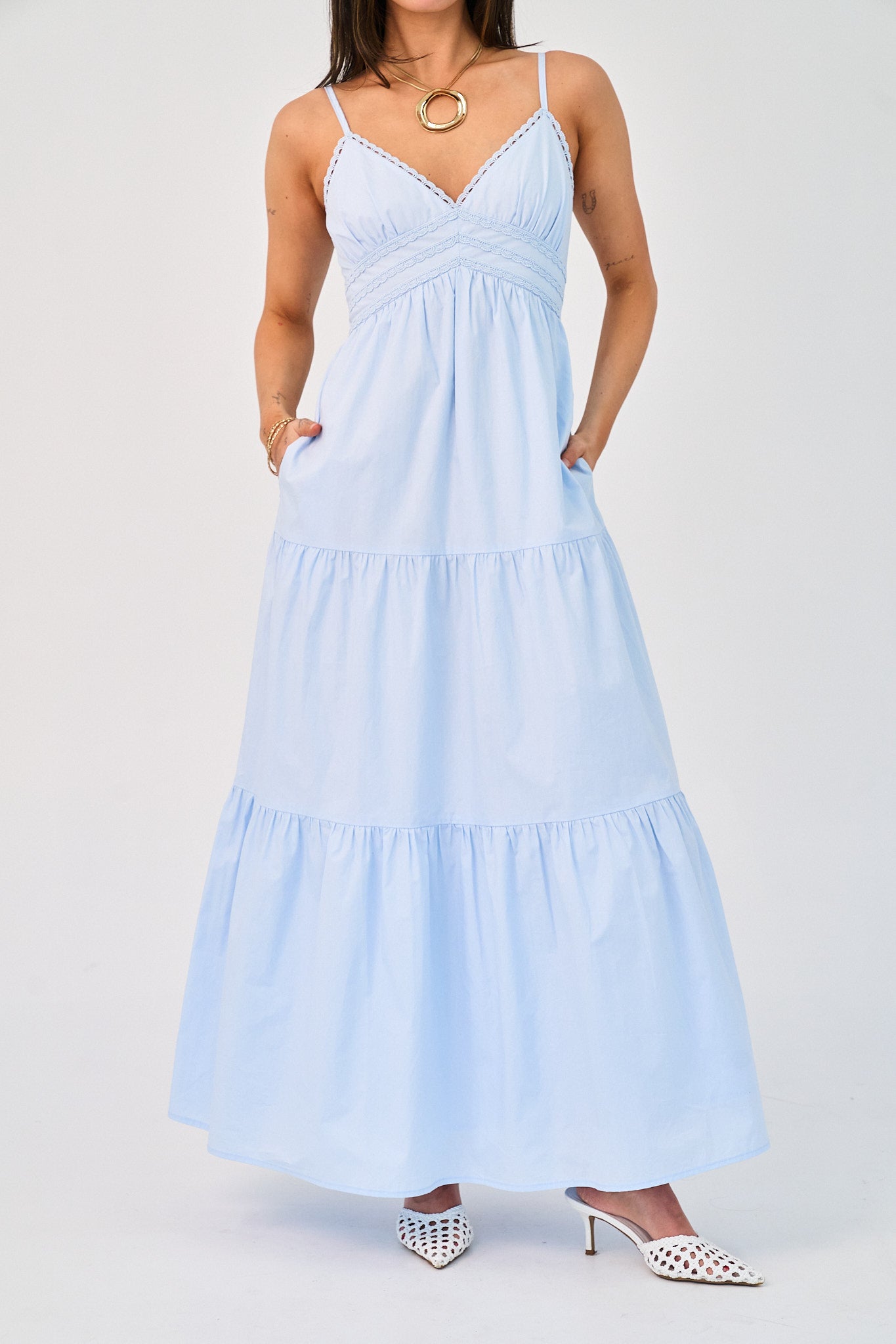 Woman wearing a light blue dress with thin straps on a white background