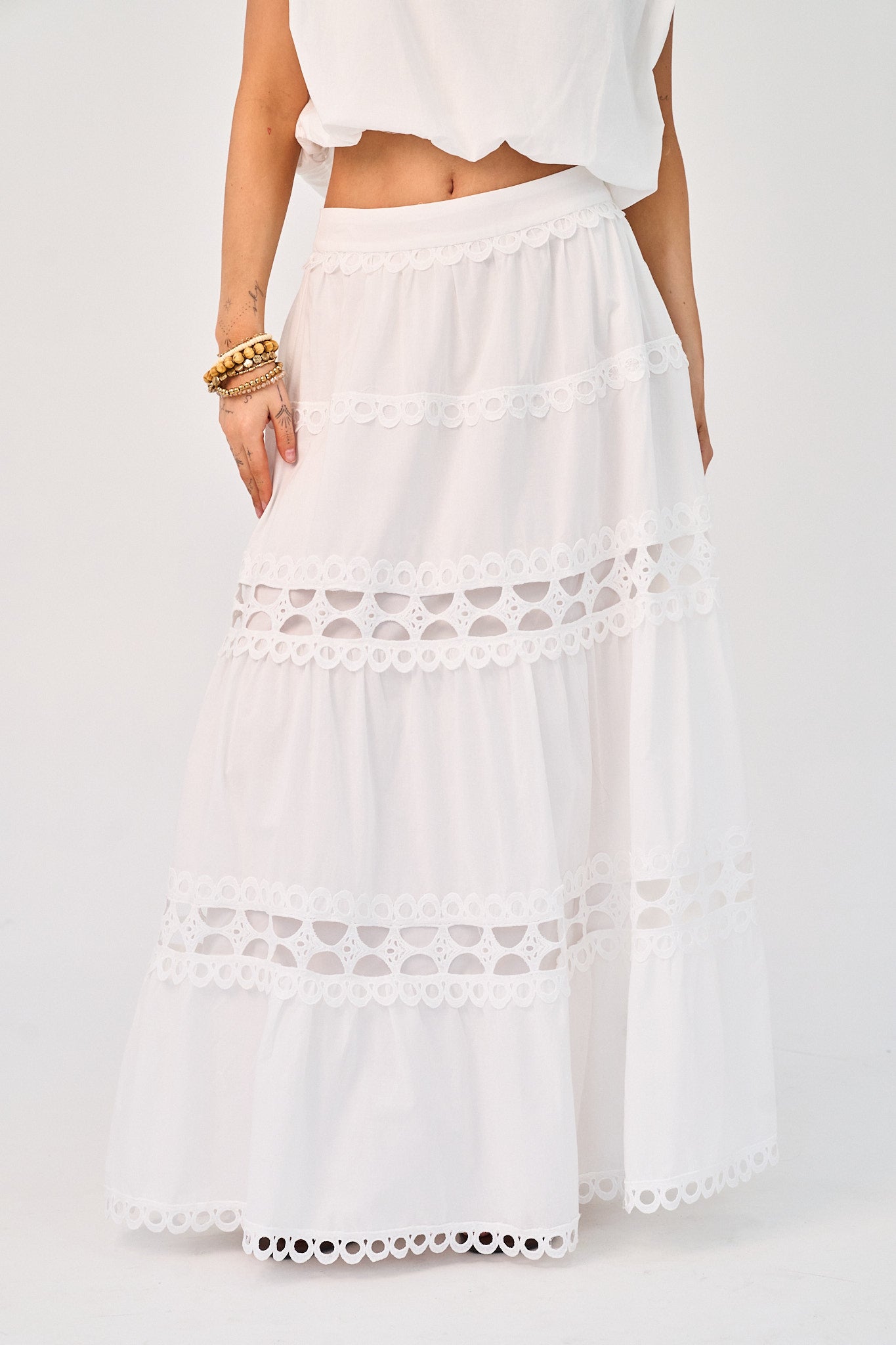 White lace-trimmed skirt worn by a person on a white background