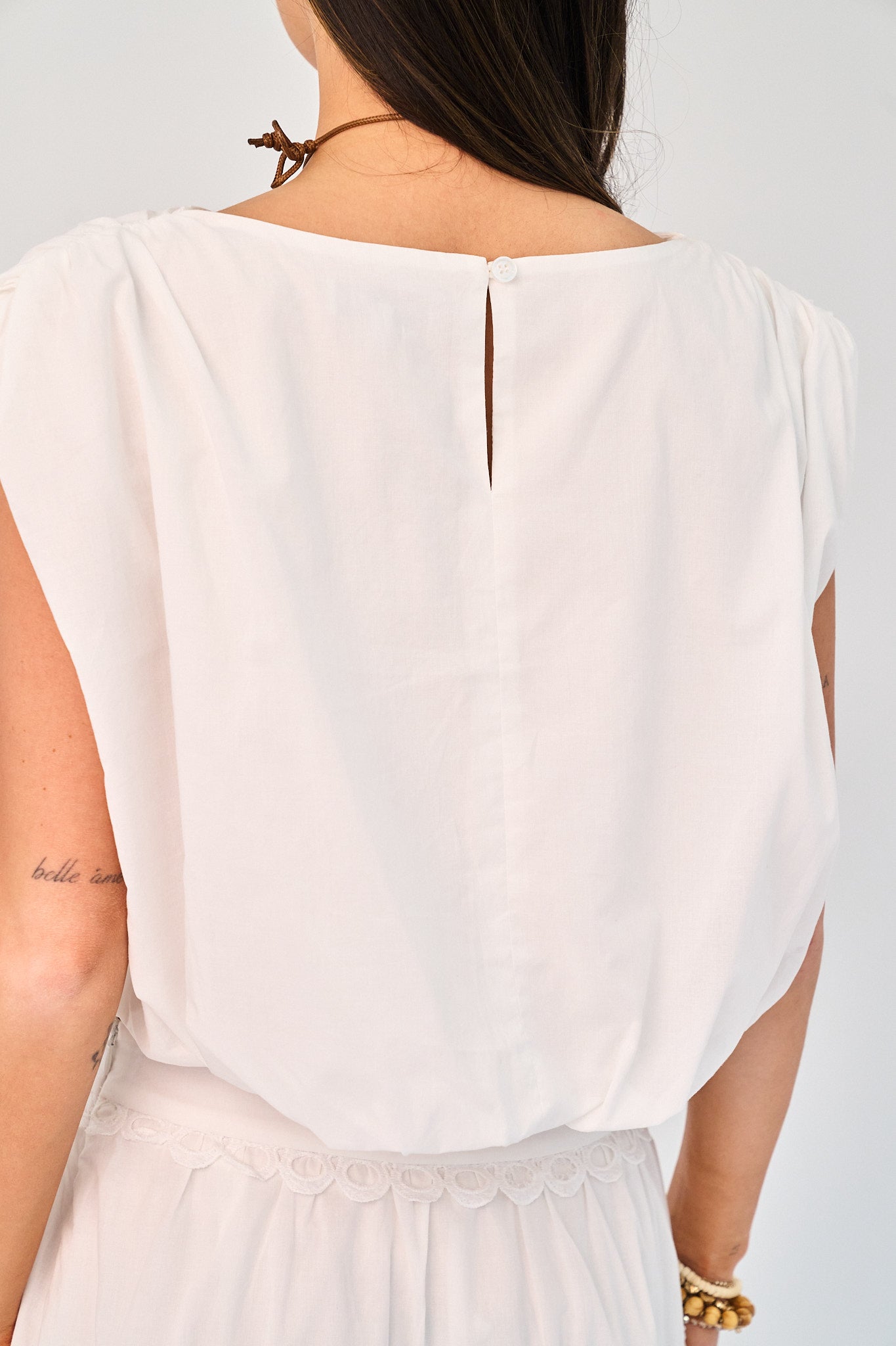 White blouse worn by a person on a plain background