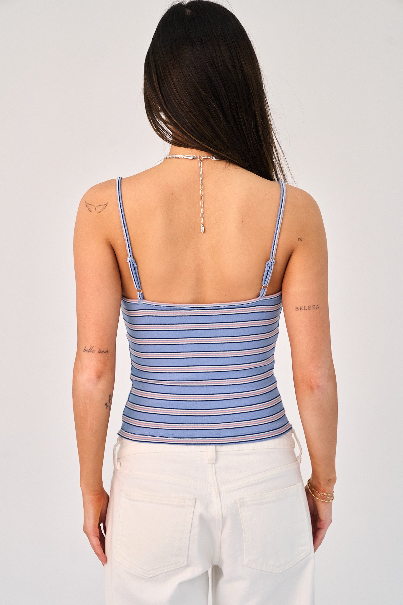 Woman wearing a blue striped tank top against a white background