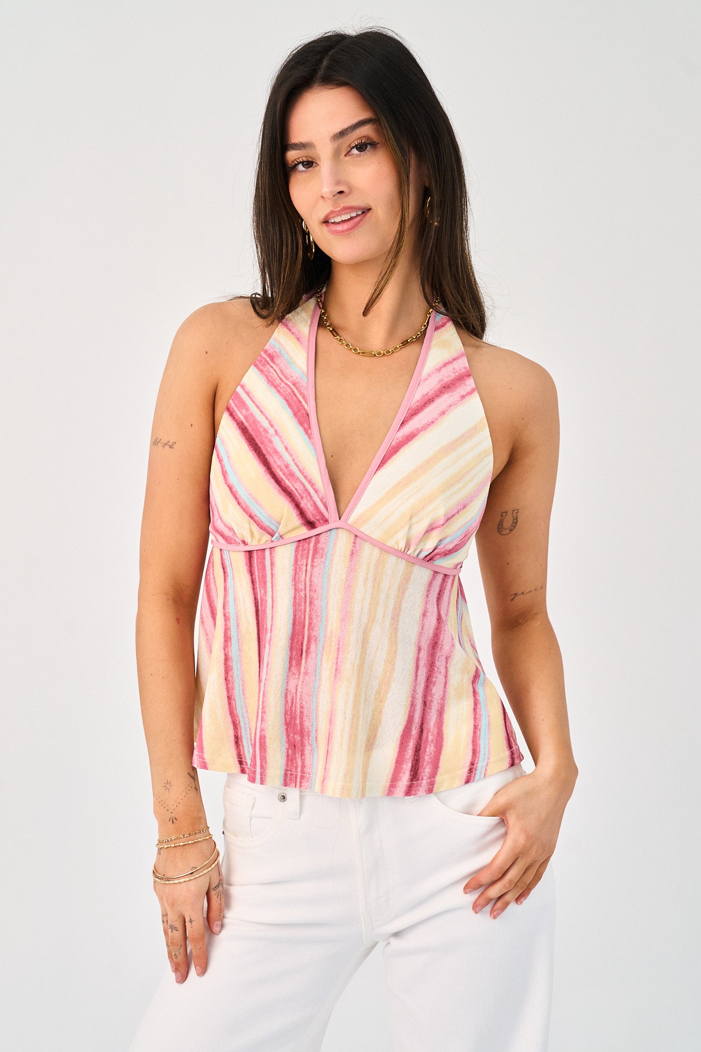 Woman wearing a colorful halter top with a white background