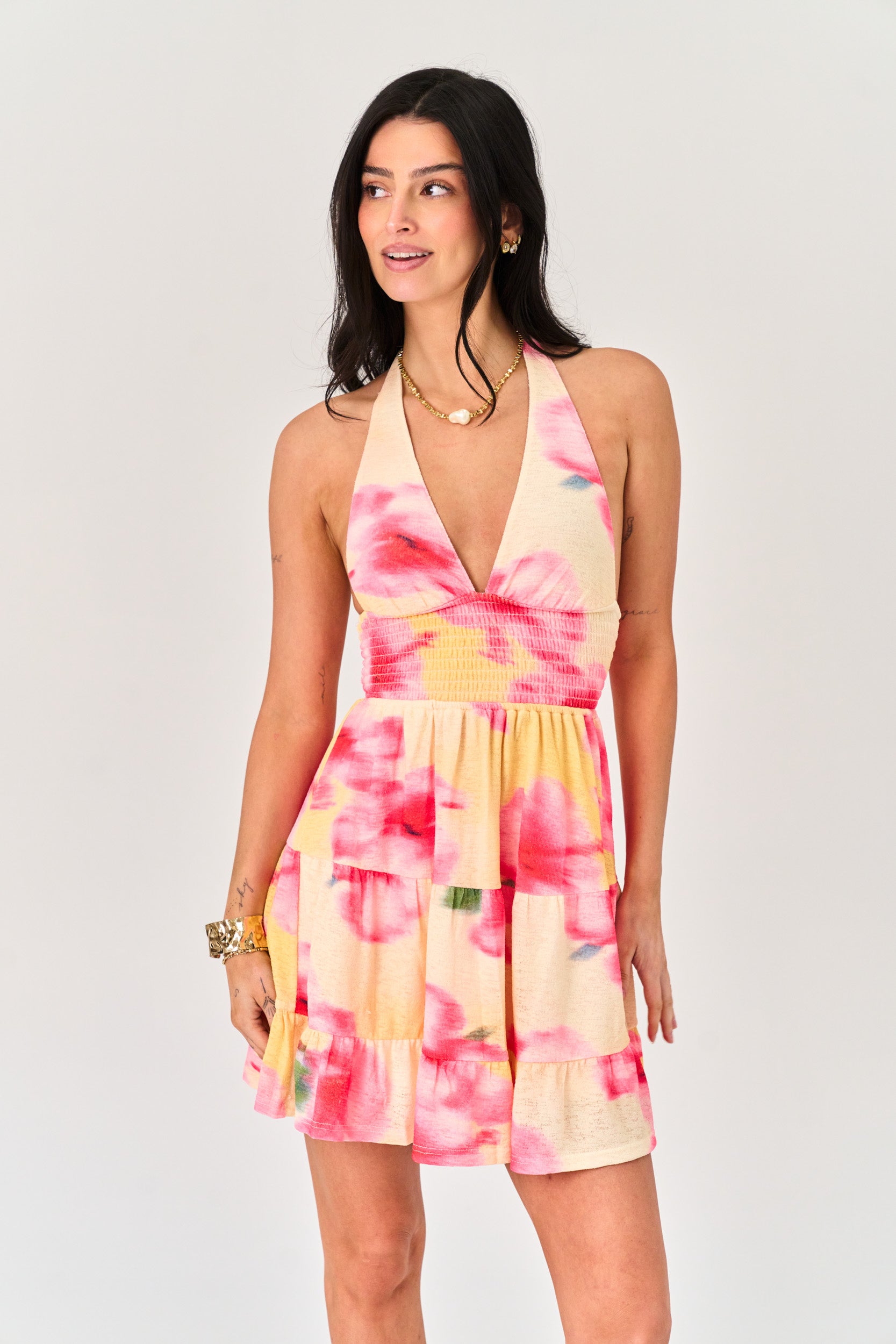 Woman wearing a colorful floral dress on a plain background