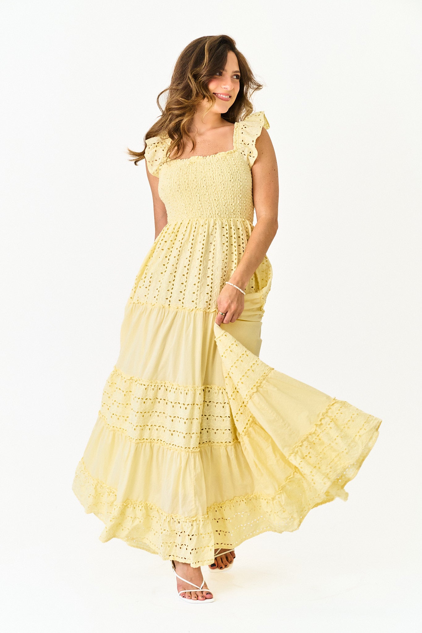 Woman wearing a yellow lace dress on a white background