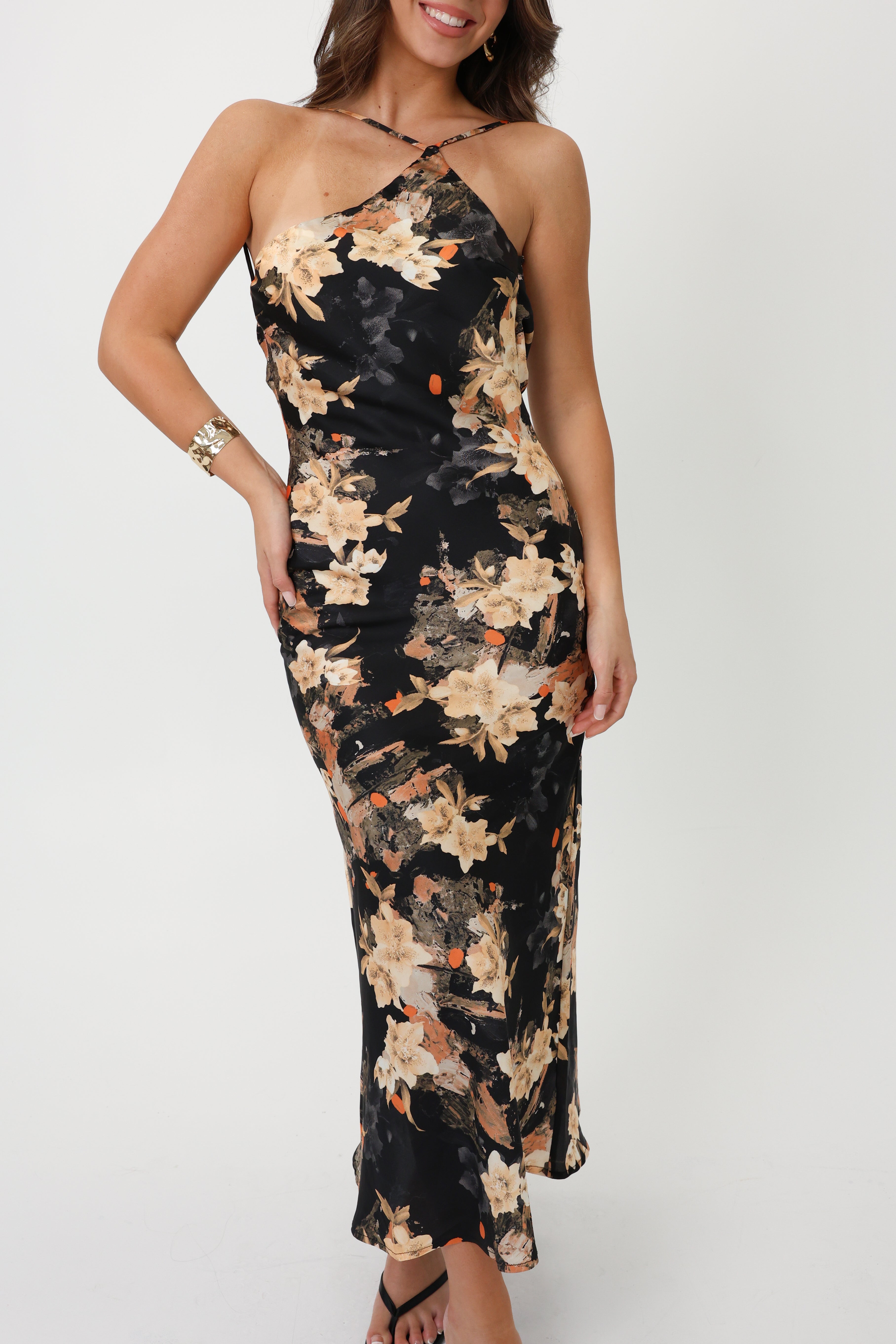 Woman wearing a halter black floral maxi dress