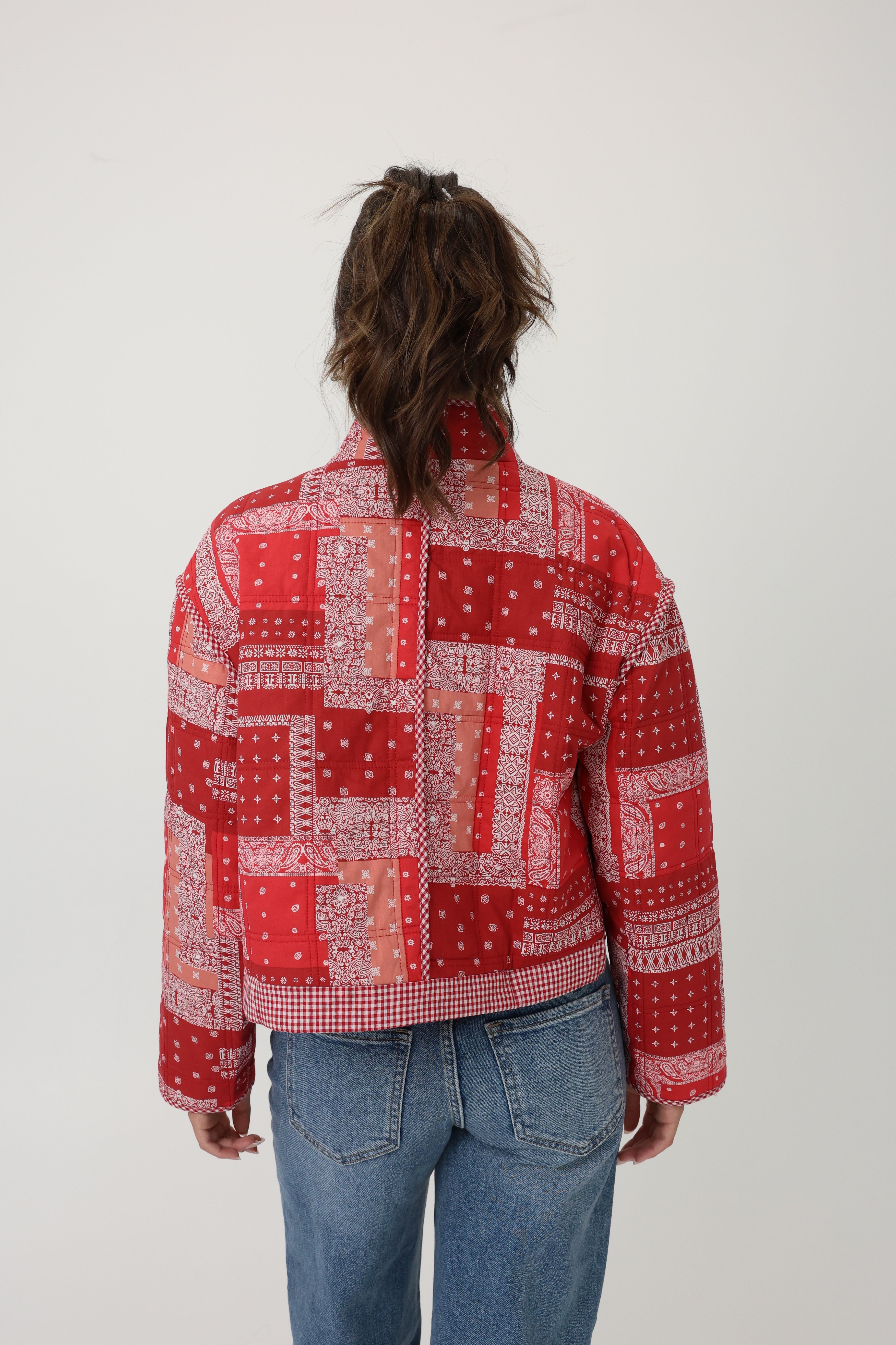 Person wearing a red patterned jacket on a white background