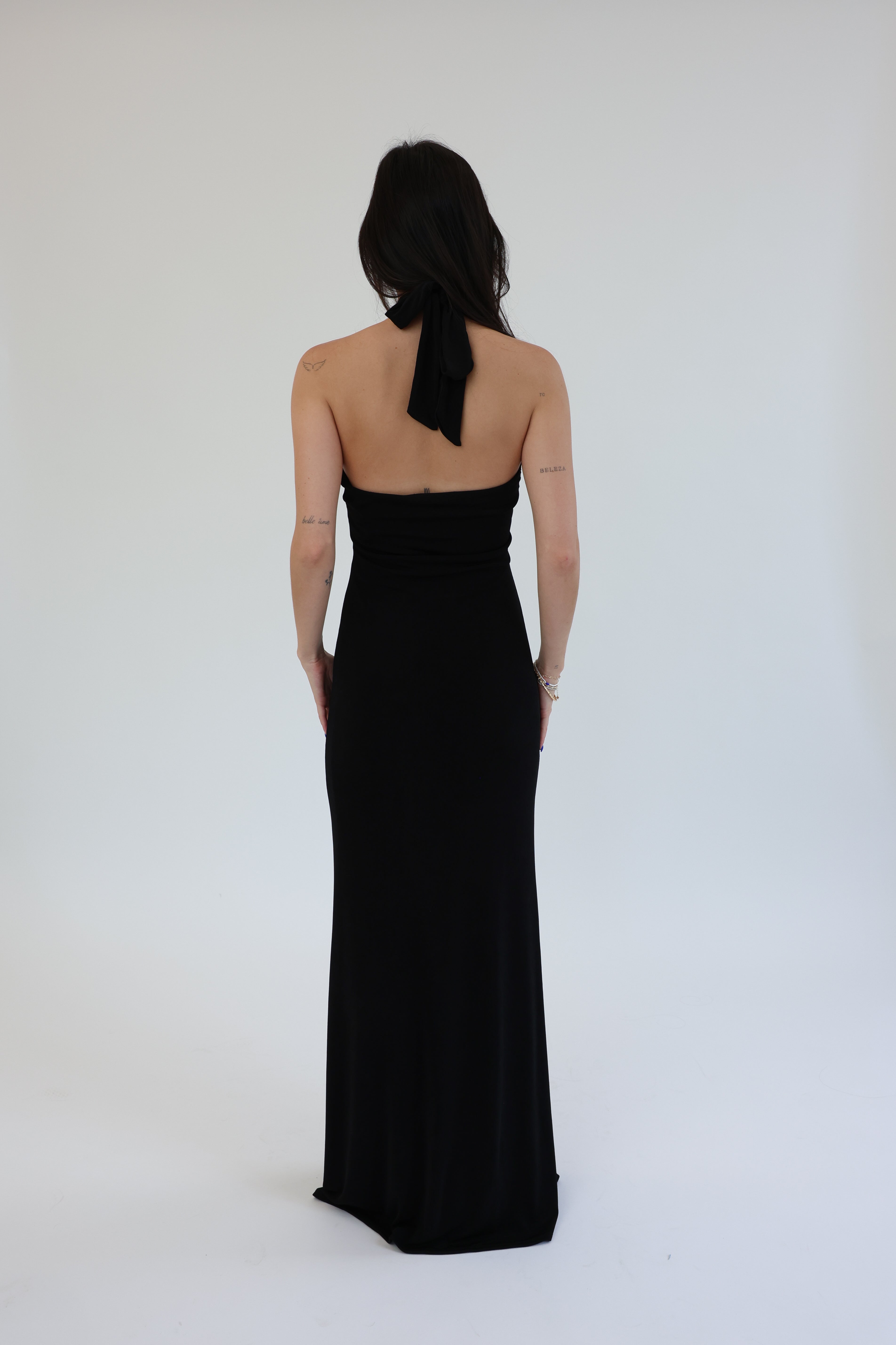 Woman wearing a black strapless gown against a white background