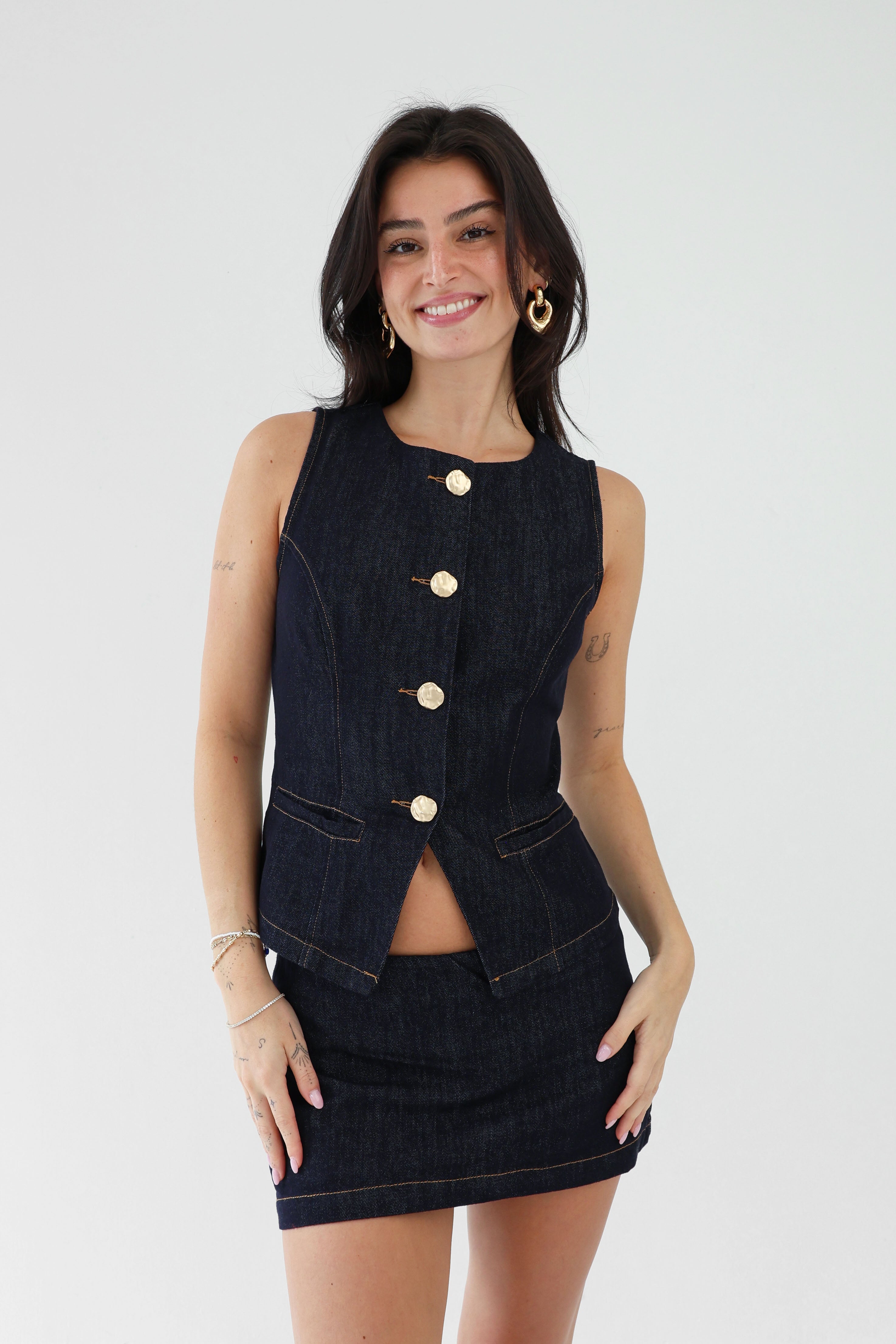 Woman wearing a black denim vest and skirt set on a white background