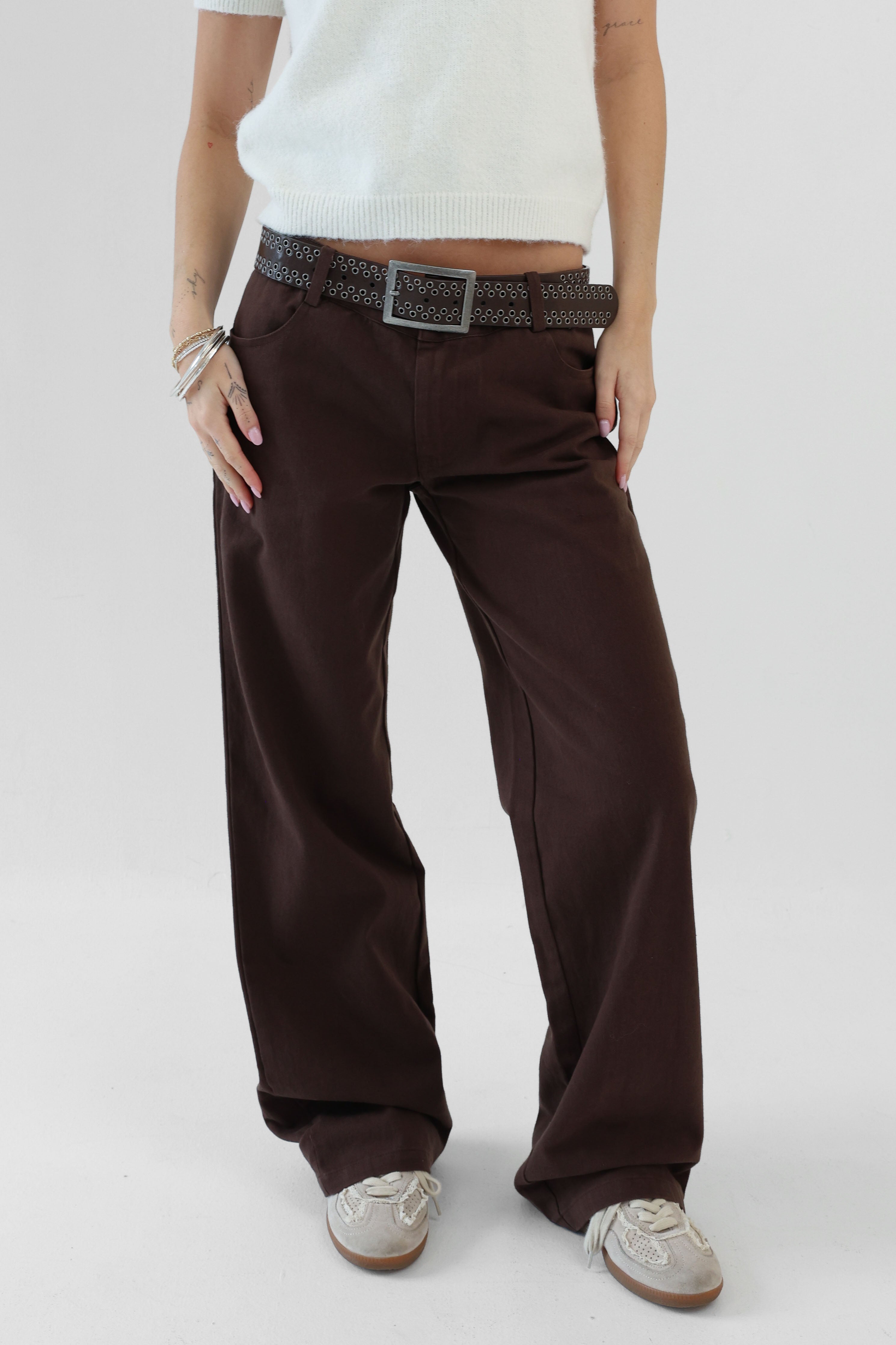 Person wearing brown pants with a white background