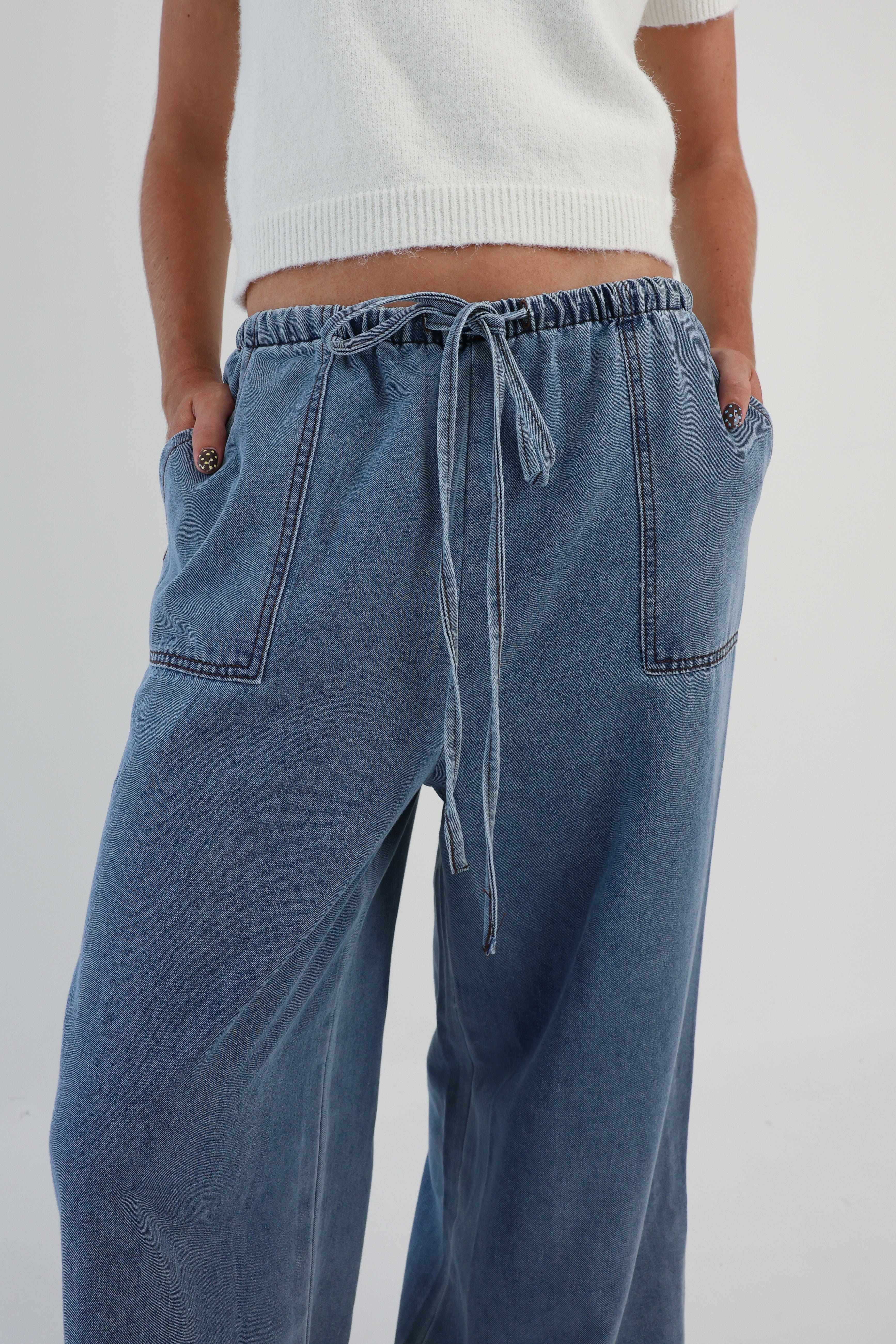 Blue jeans with a drawstring waist on a white background