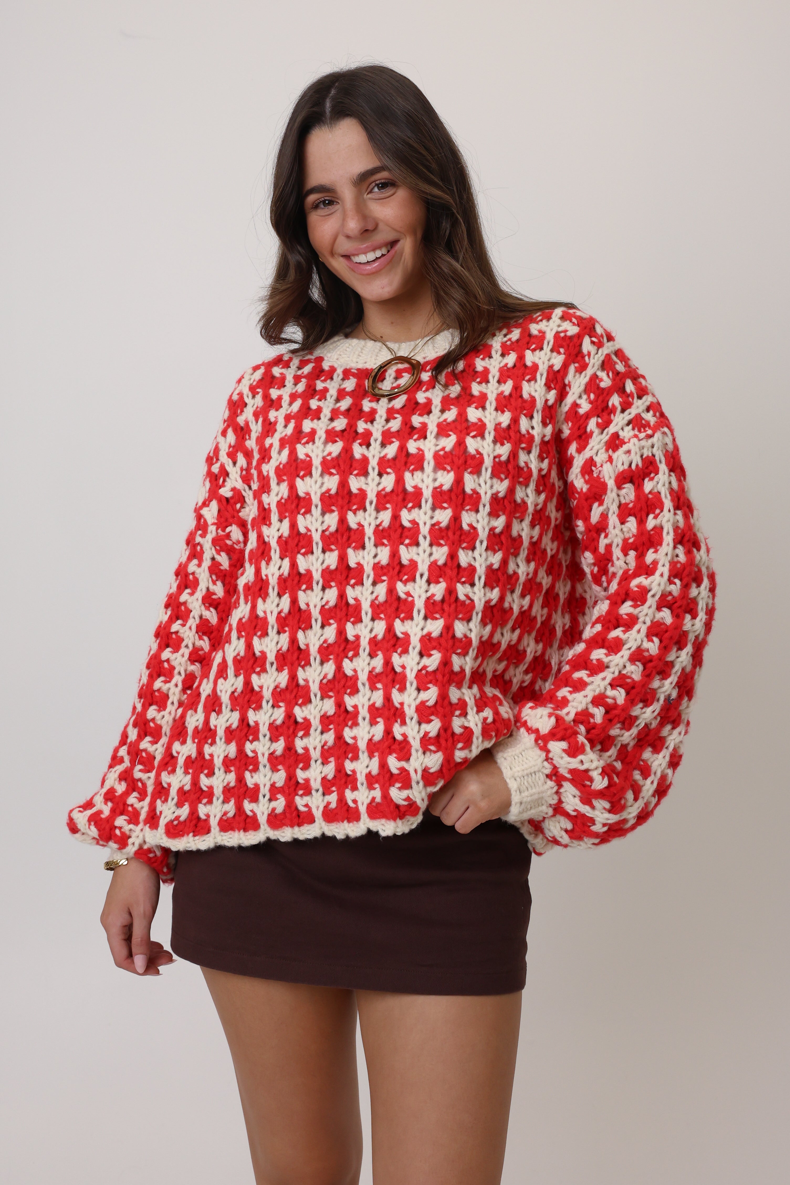 Woman wearing a red and white checkered sweater on a plain background