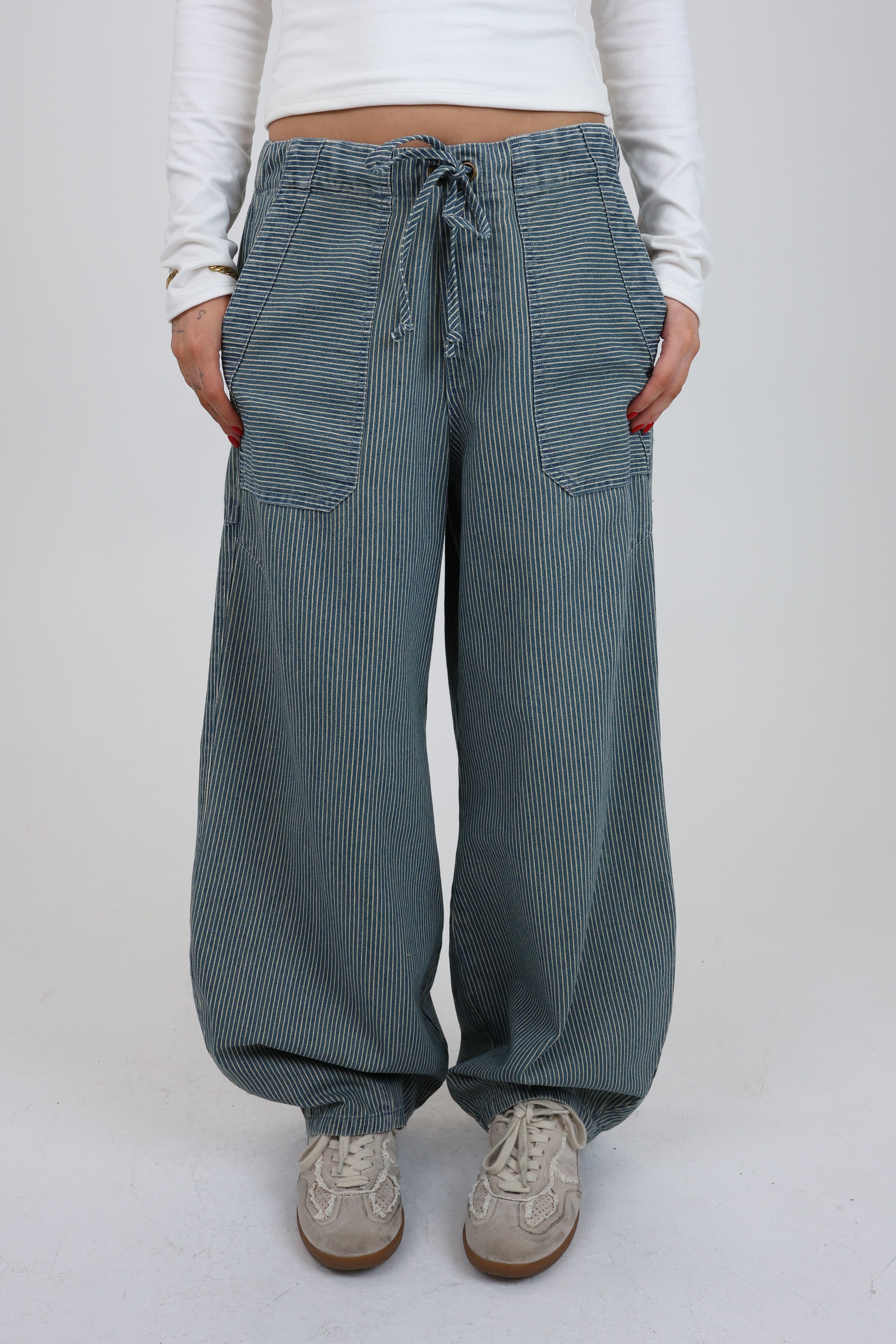 Person wearing blue striped pants on a white background