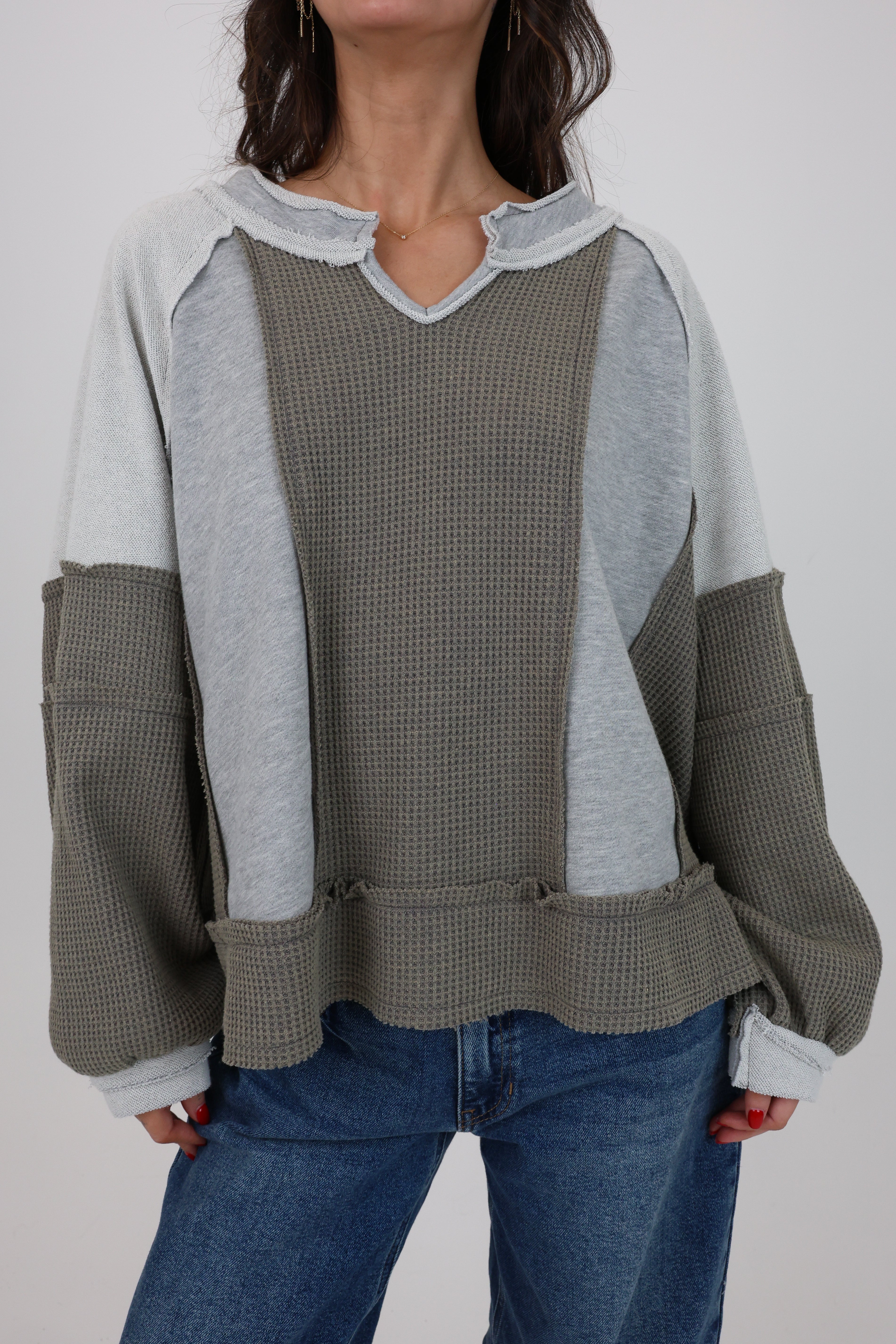 Person wearing a gray and green checkered shirt with a plain background