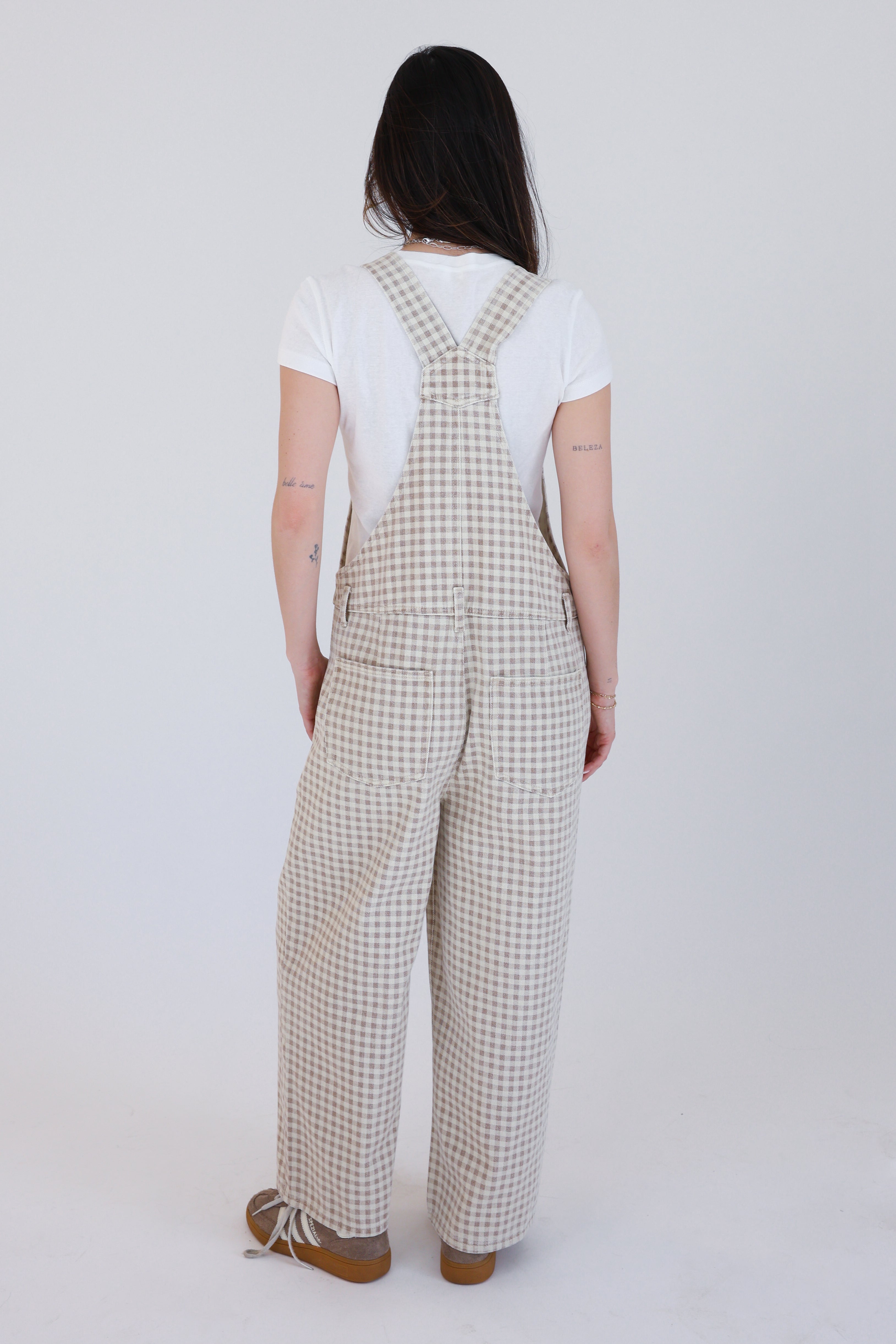 Person wearing checkered overalls on a white background