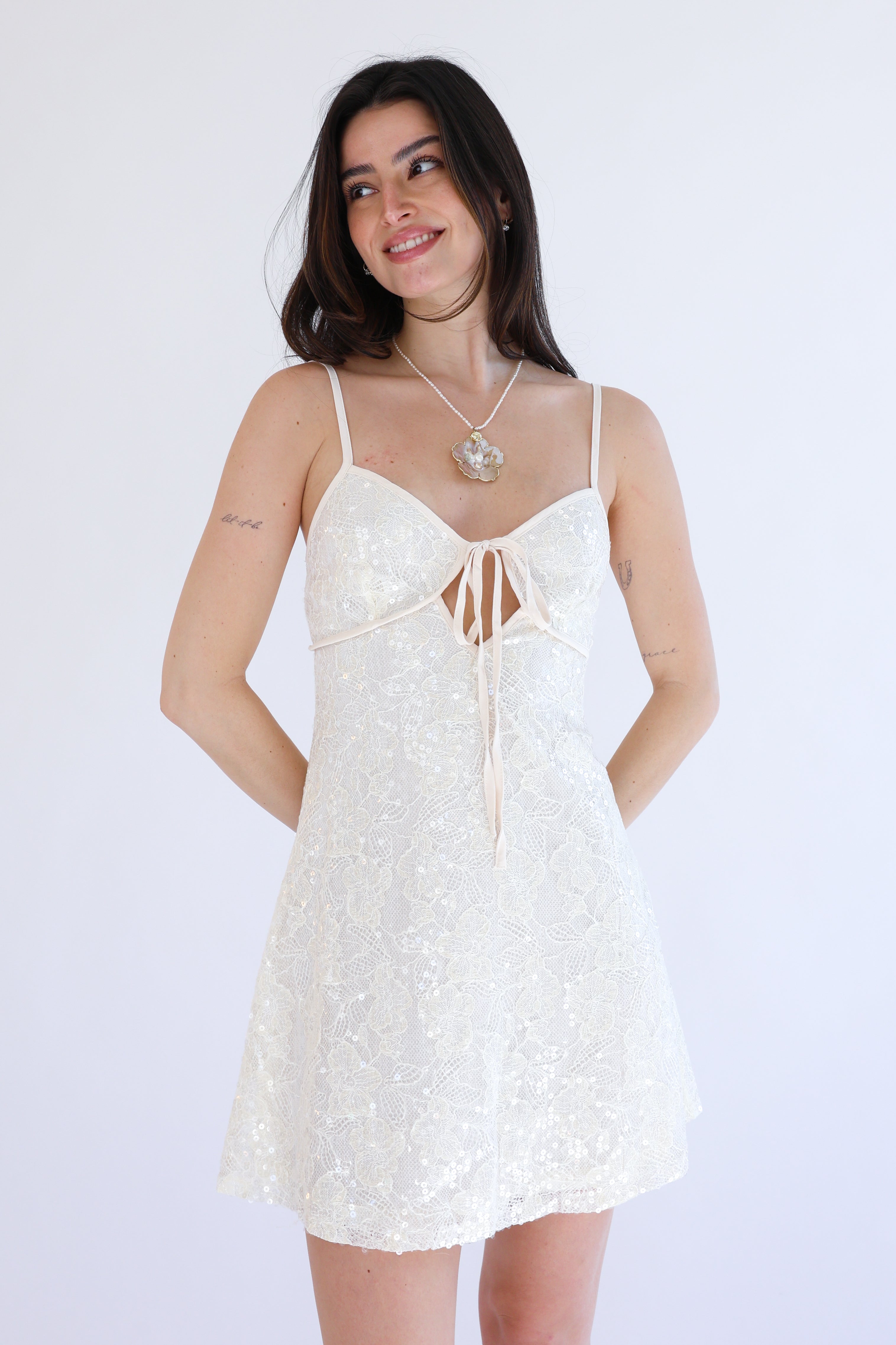 Woman wearing a white lace dress against a white background