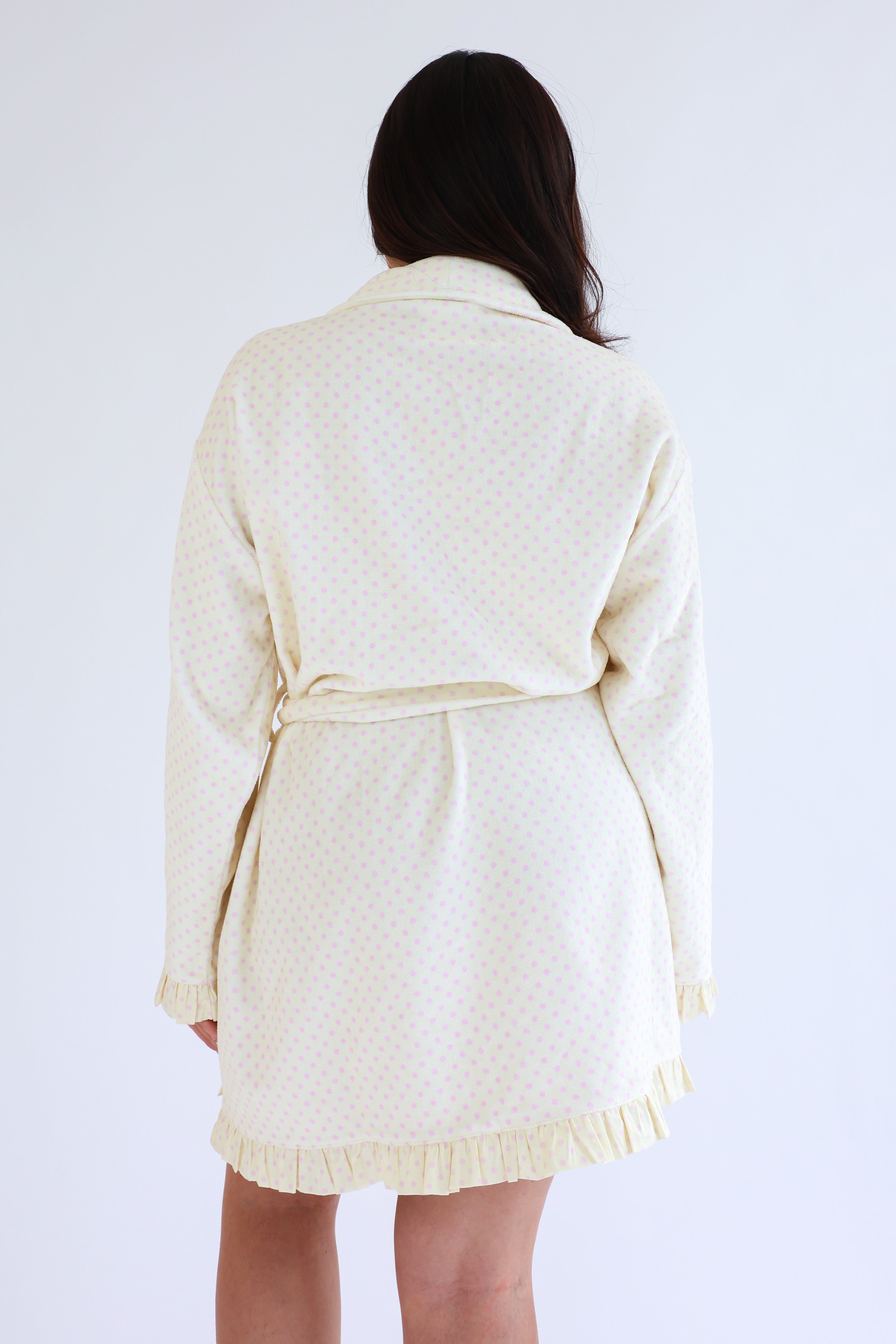 Person wearing a cream-colored cardigan on a white background