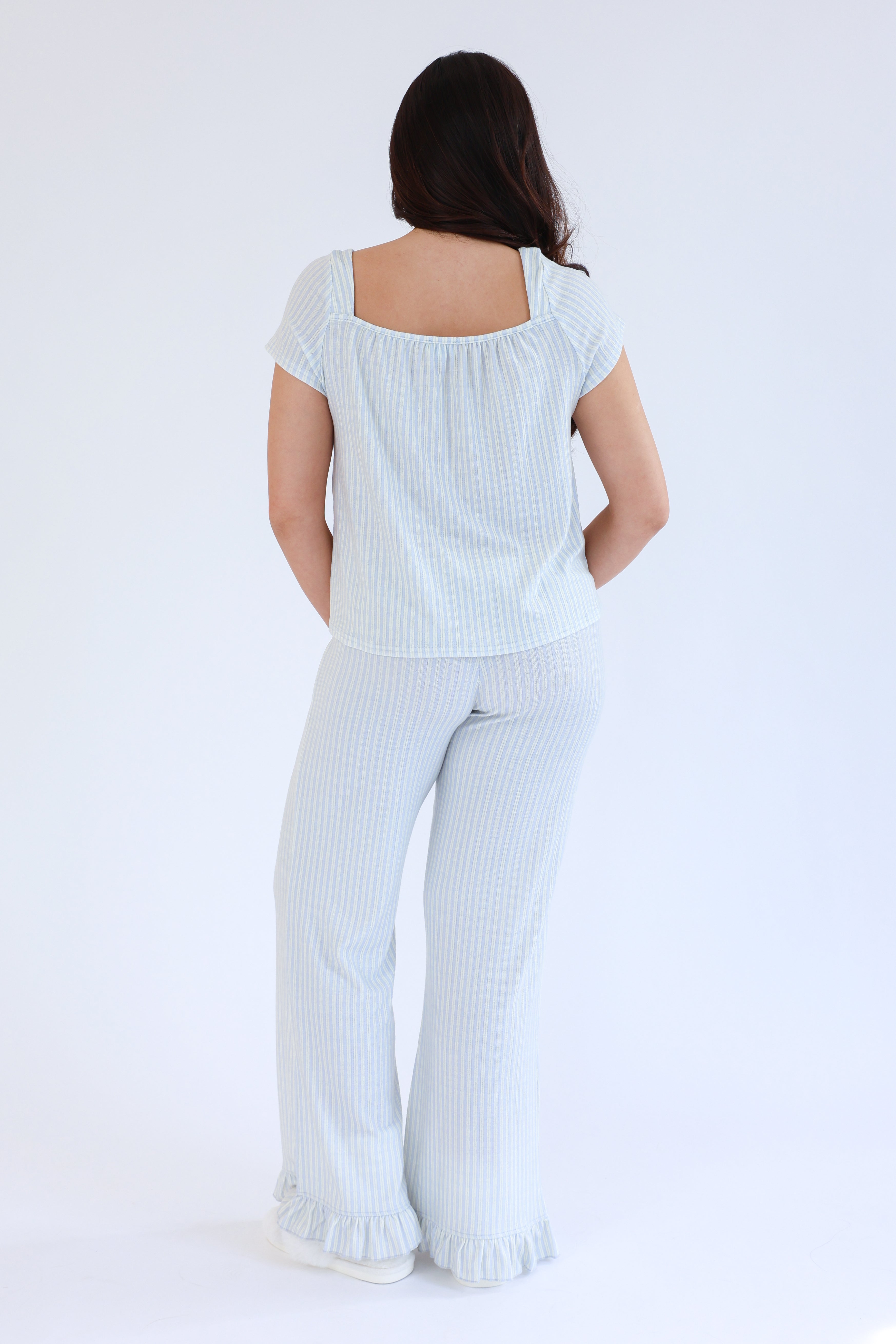 Woman wearing a light blue striped outfit on a white background