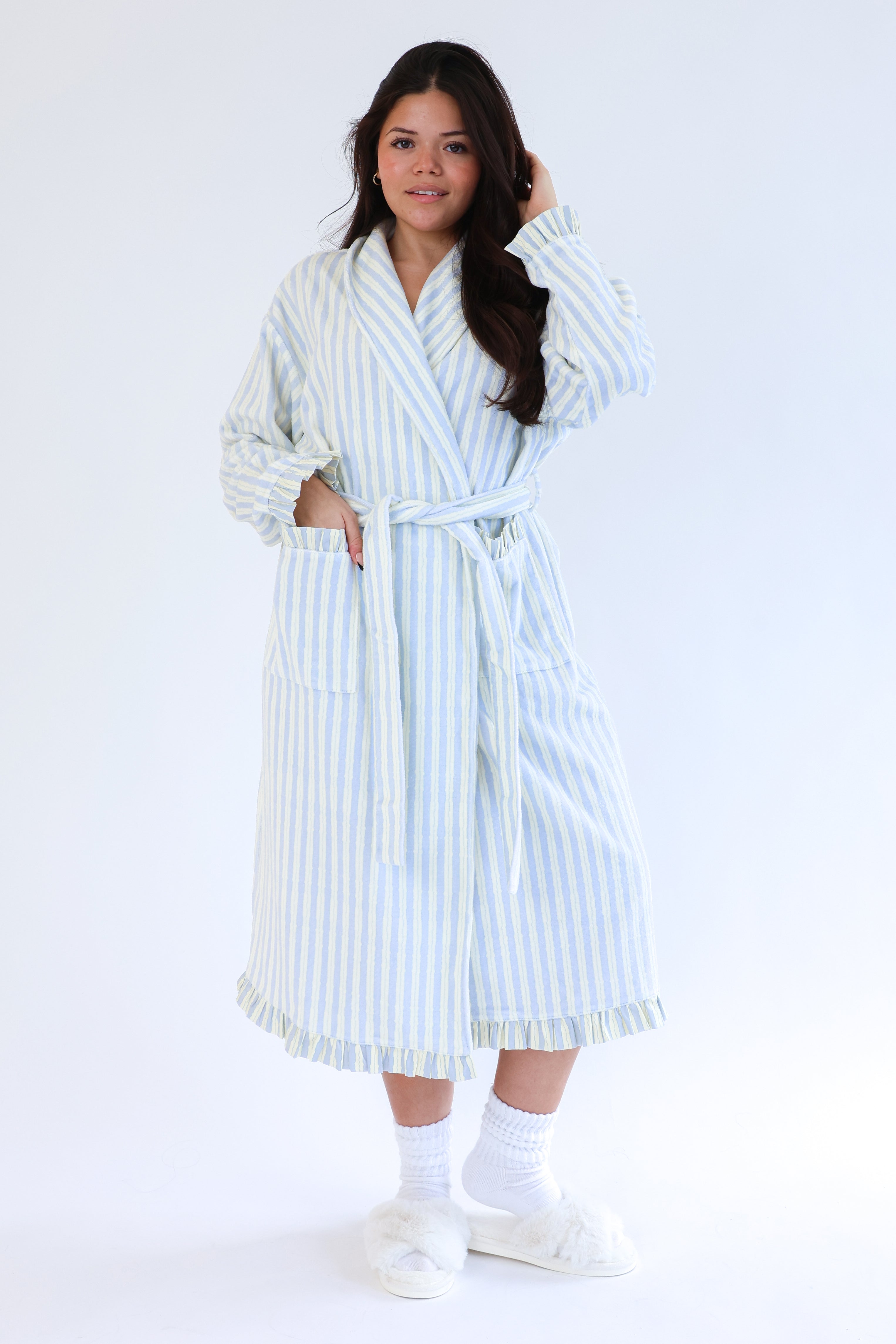 Woman wearing a white and blue striped robe on a white background