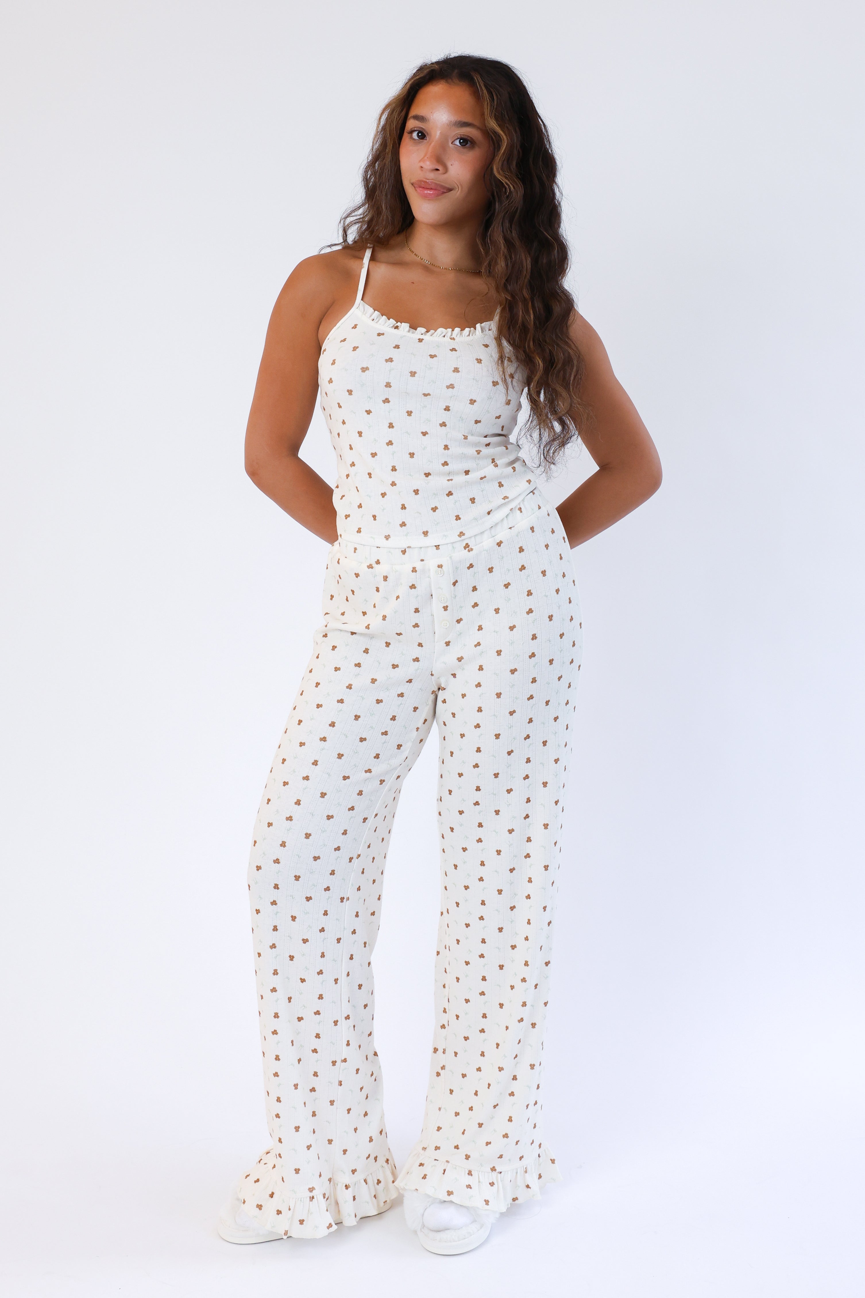 Woman wearing a white polka dot jumpsuit on a white background