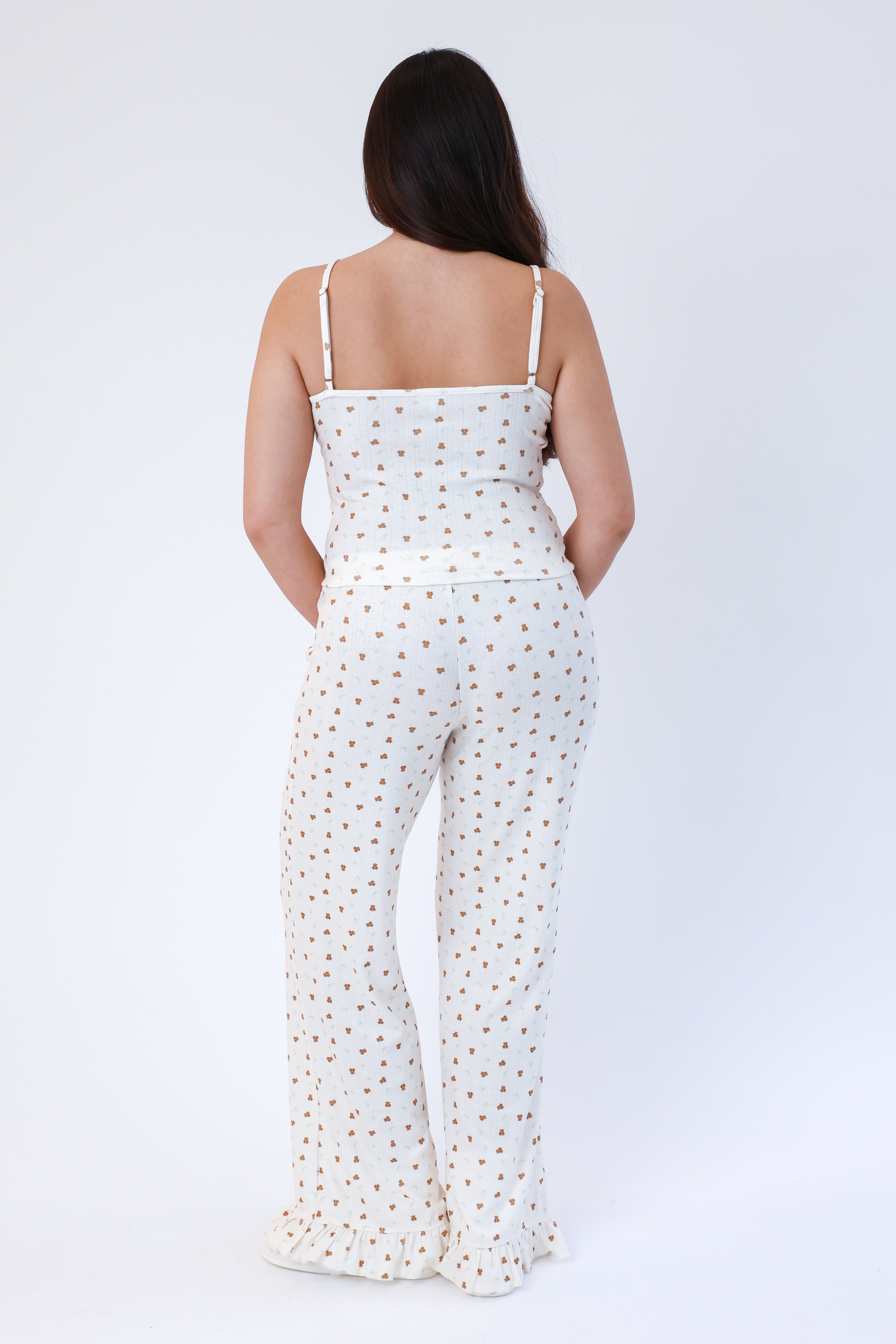 Woman wearing a white polka dot jumpsuit on a white background