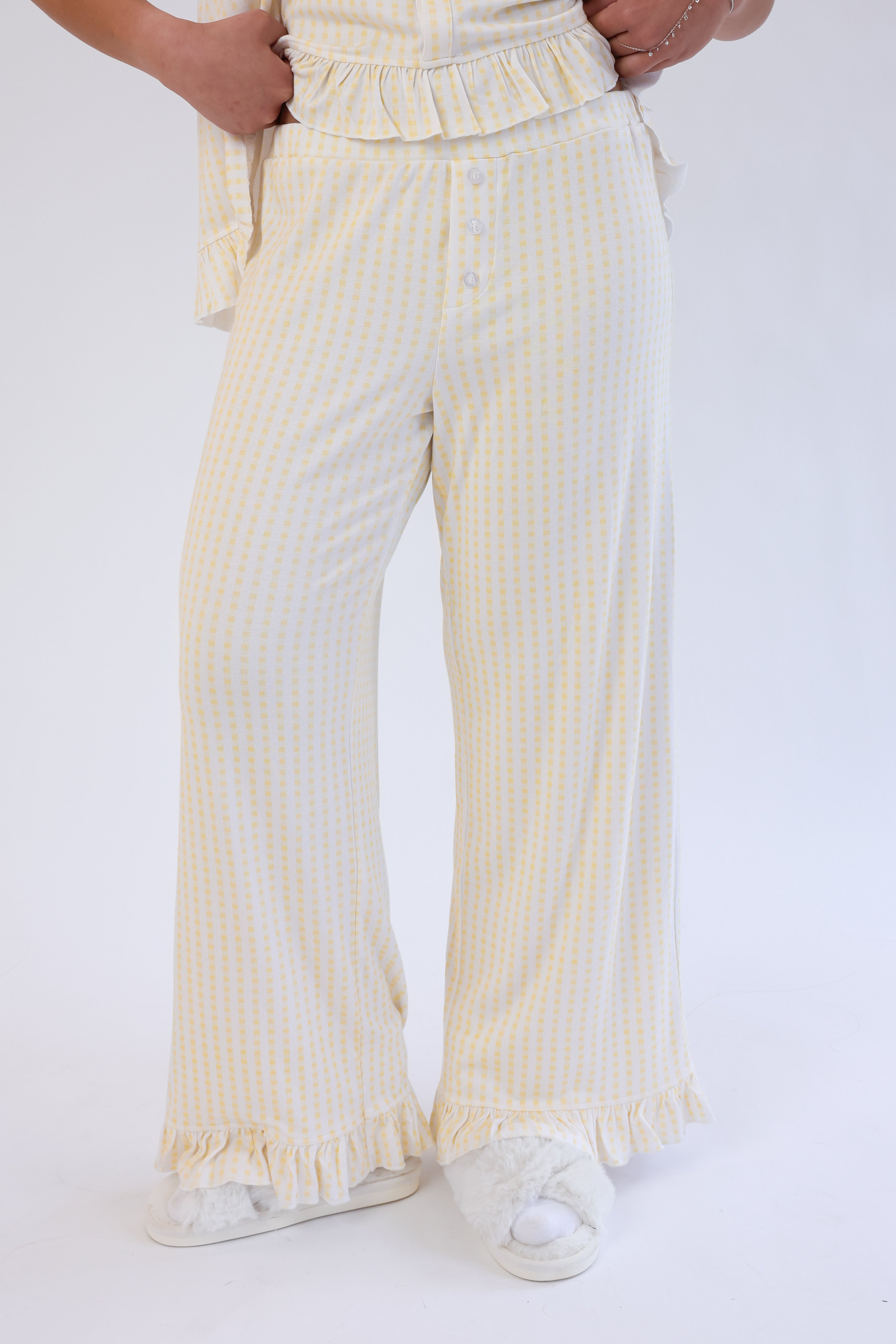 Person wearing yellow and white striped pants on a white background
