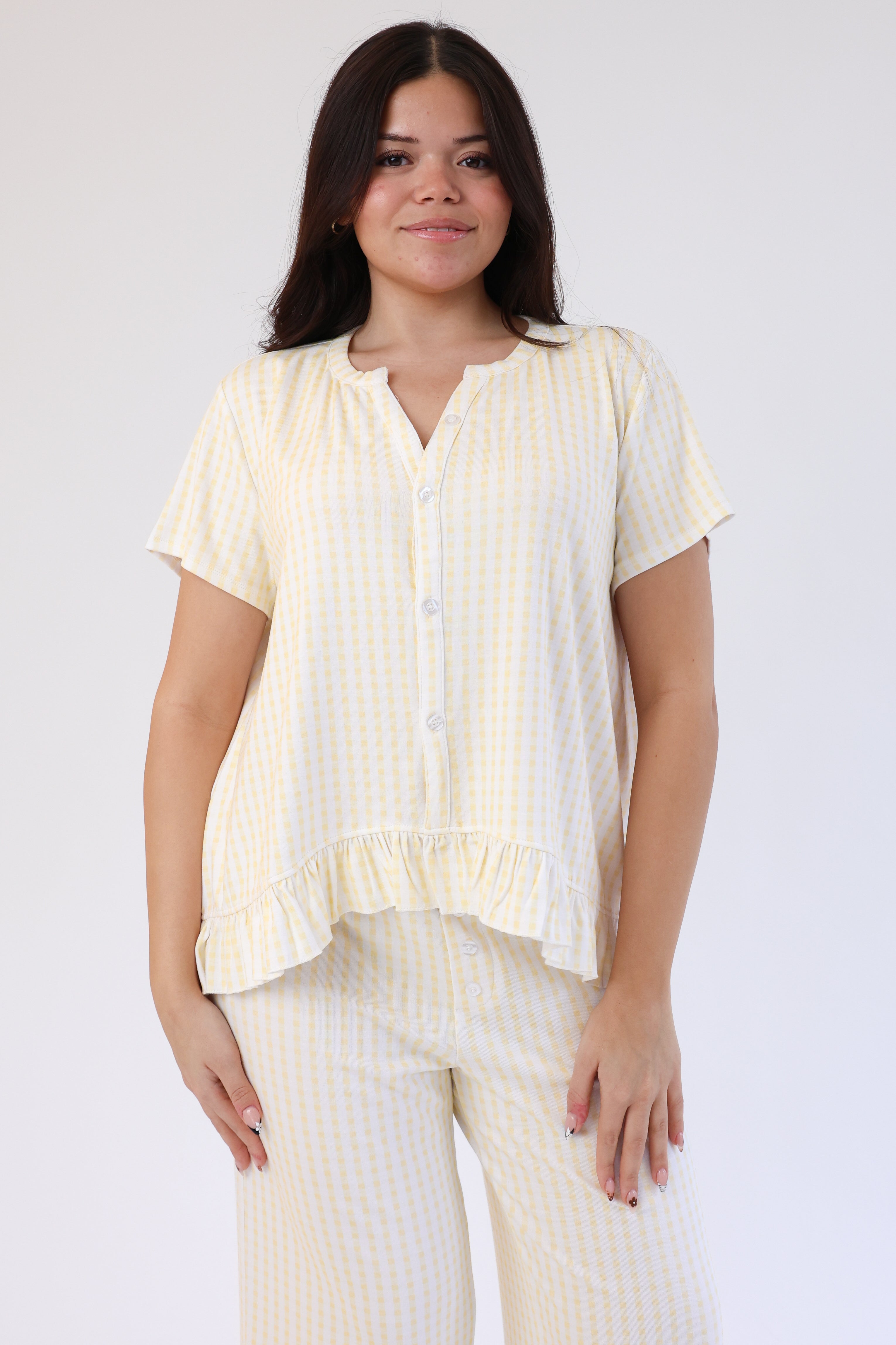 Woman wearing a yellow striped shirt and pants on a white background