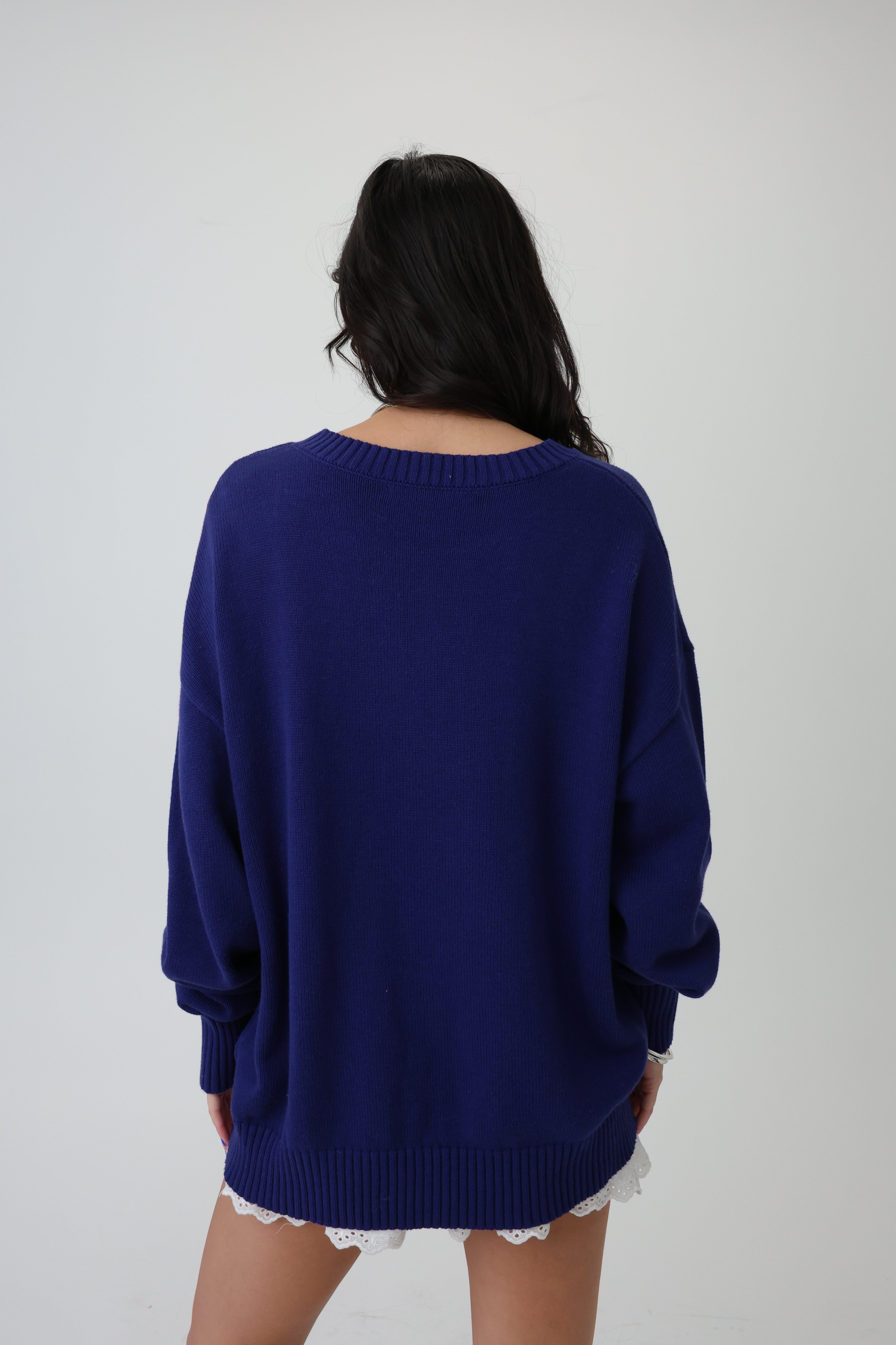 Person wearing a blue sweater on a plain background