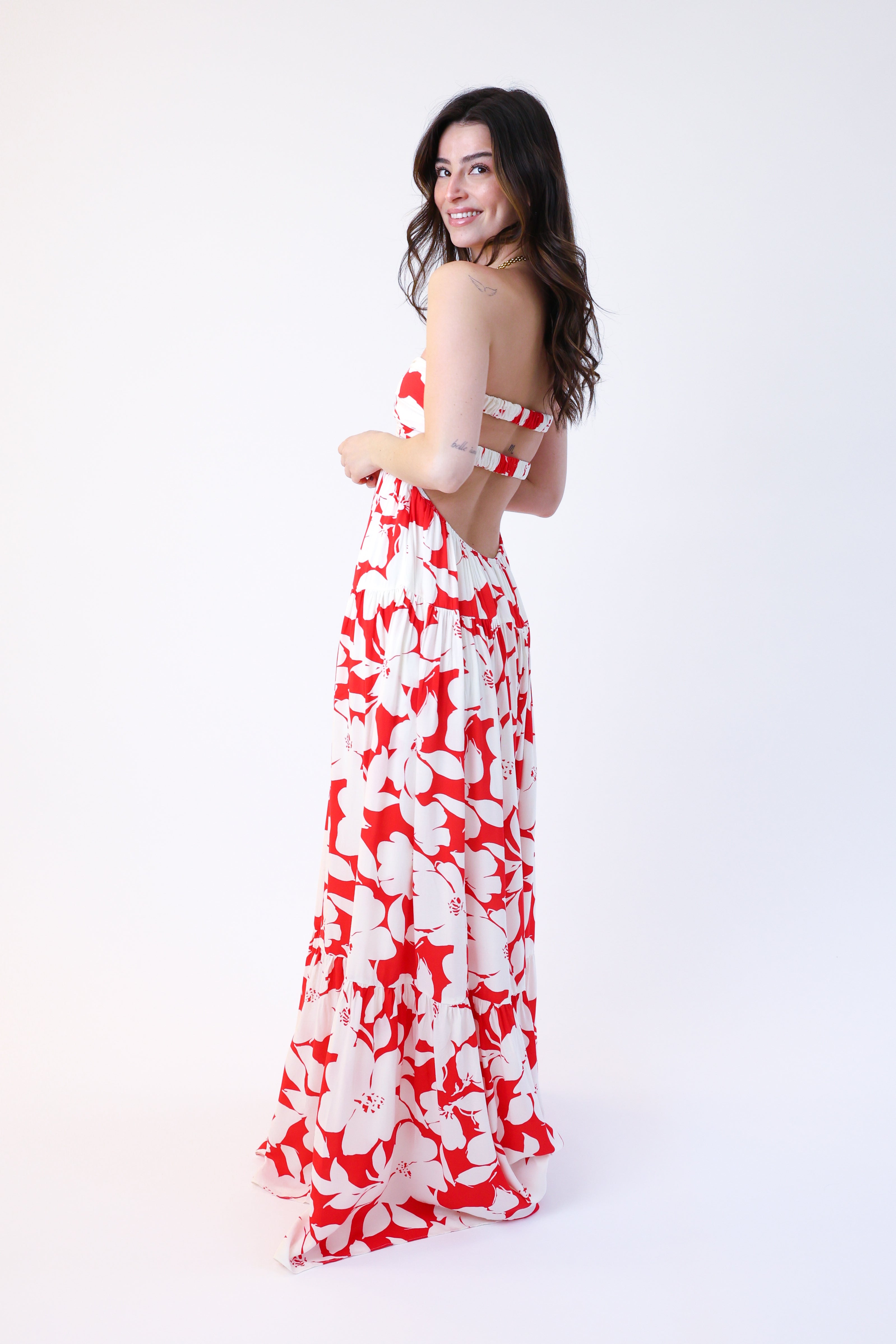 Woman wearing a red and white floral dress on a white background