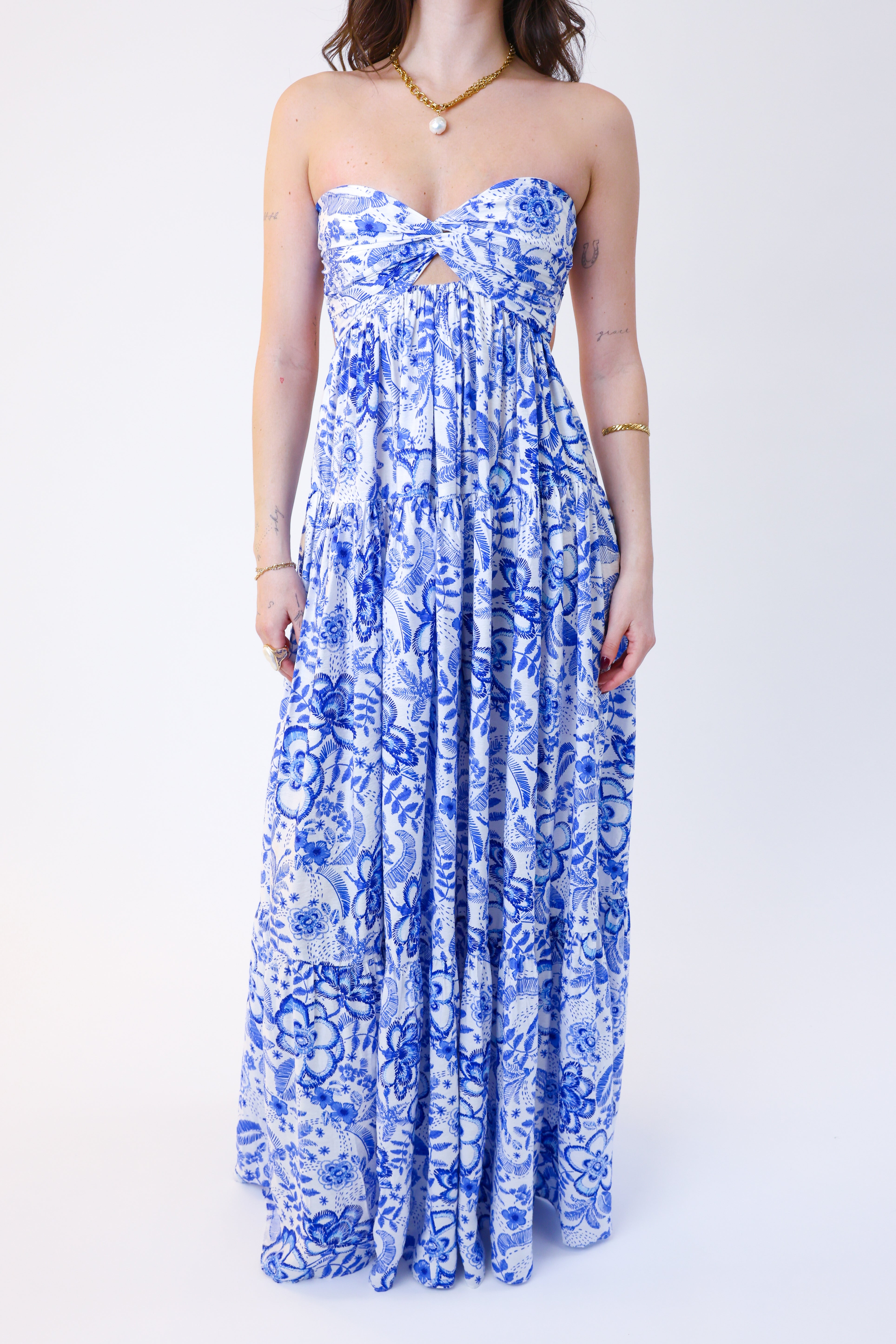 Woman wearing a blue floral strapless dress on a white background