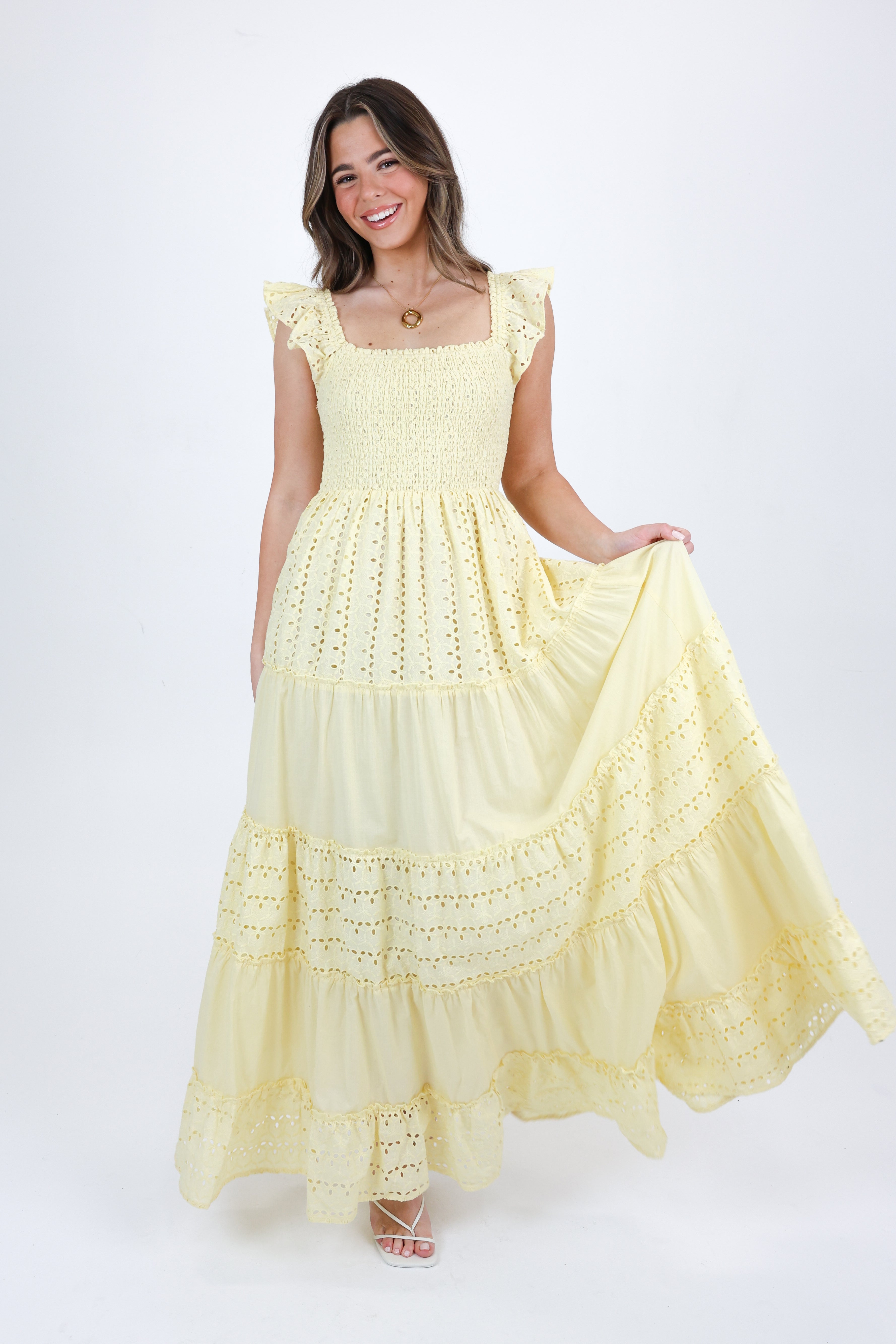 Woman wearing a yellow lace dress on a white background