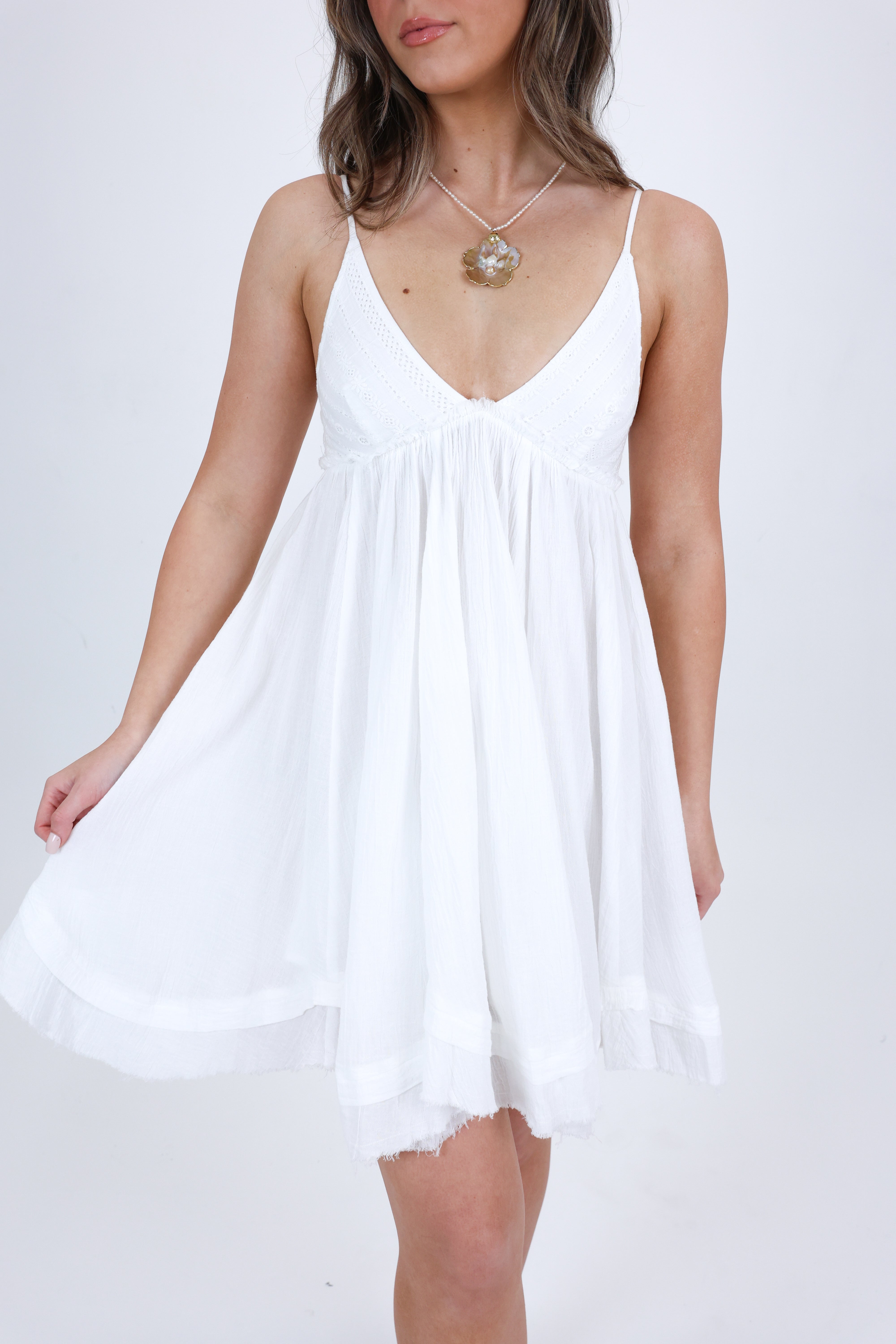 Woman wearing a white dress against a plain background