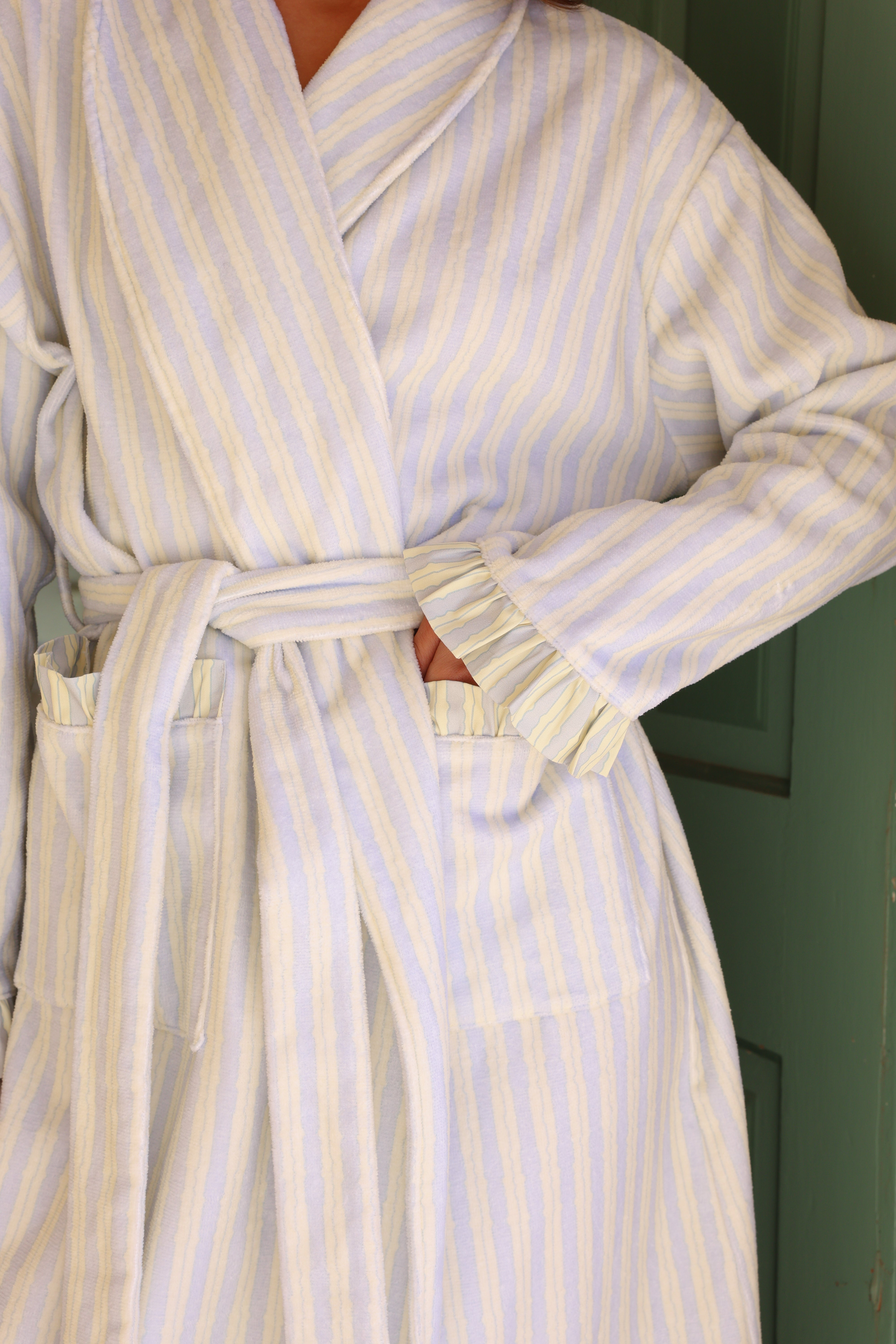 Person wearing a white and blue striped robe indoors.