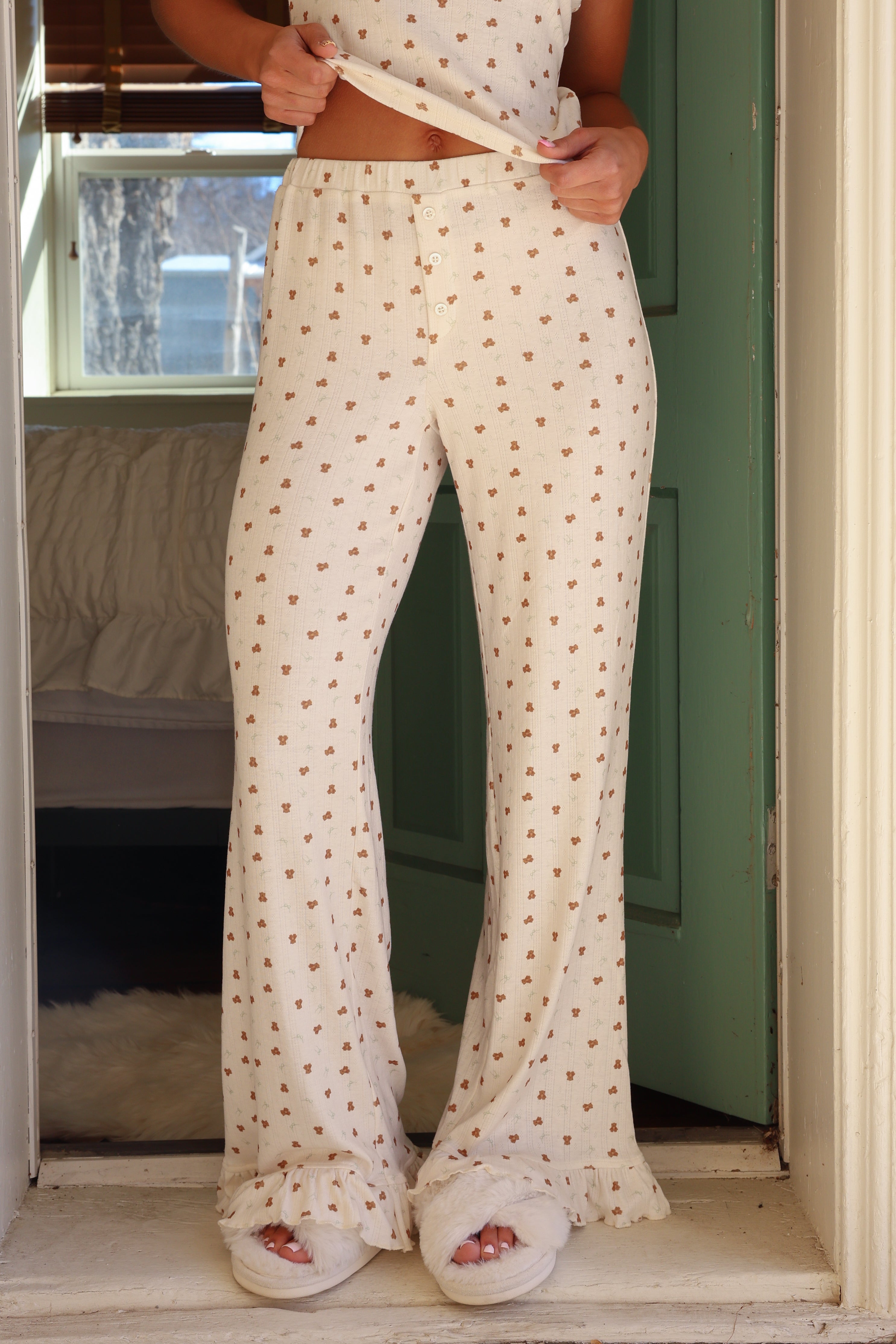 Person wearing a patterned outfit standing in a doorway.