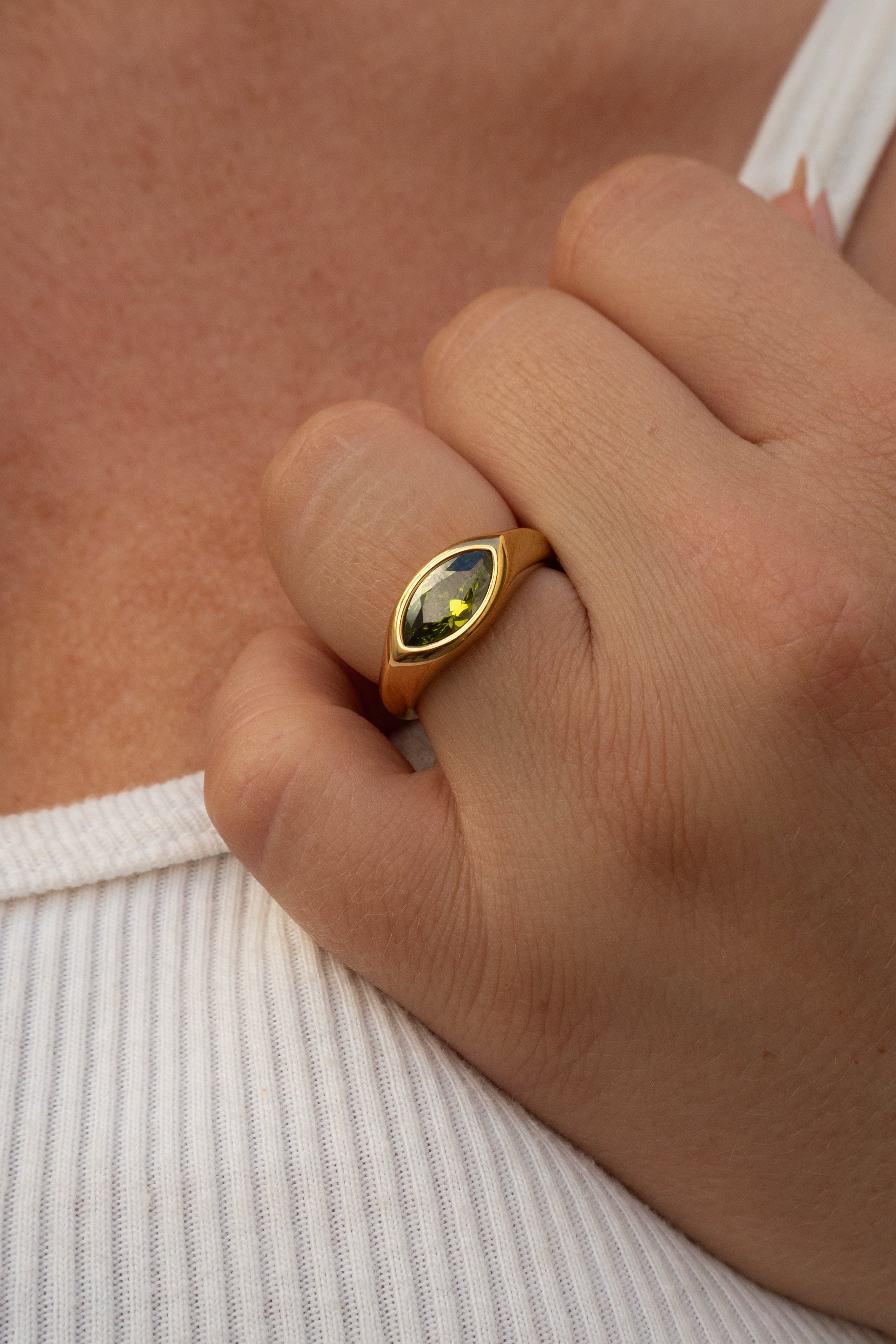 Gold ring with a gemstone on a person's finger