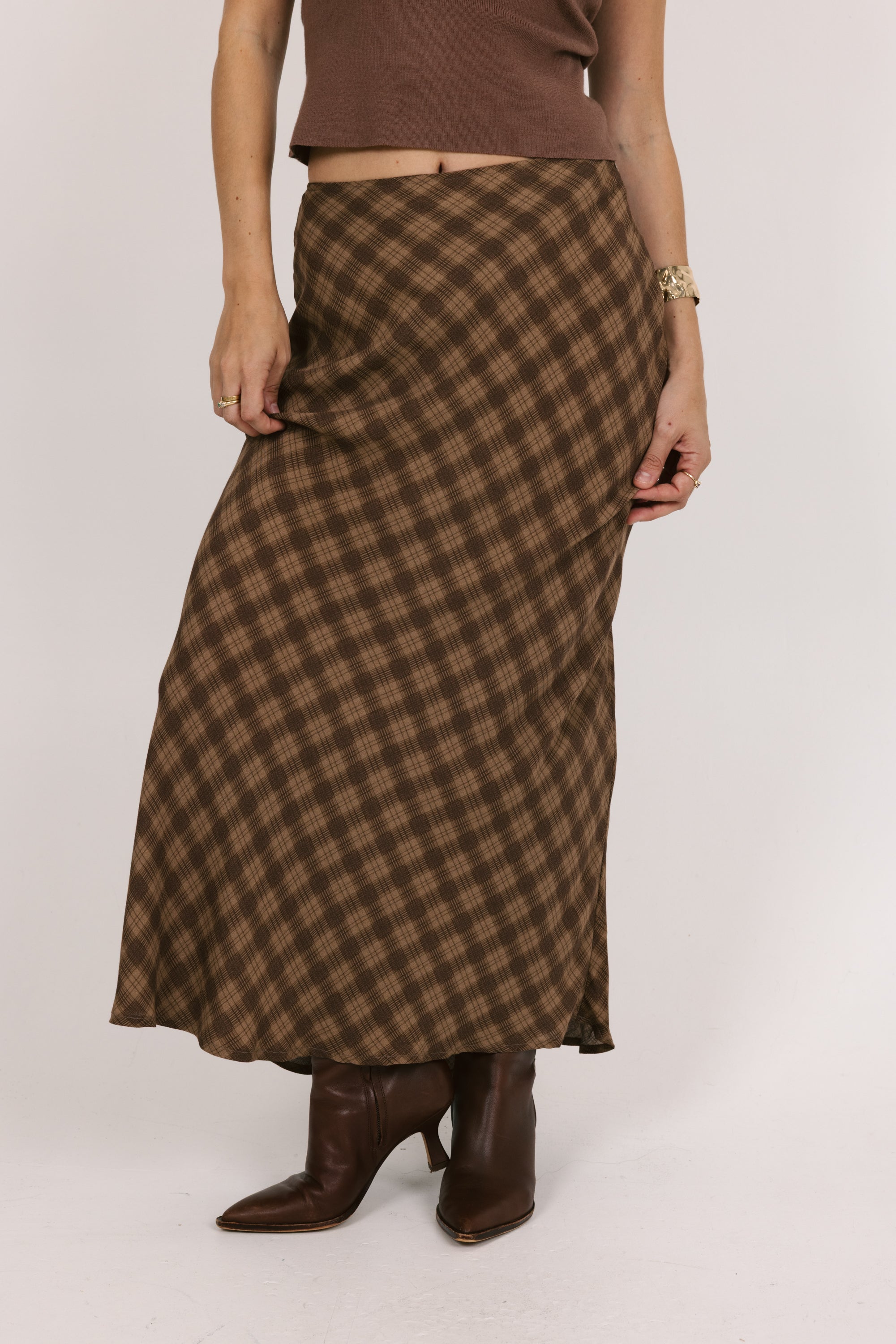 Person wearing a brown plaid skirt on a white background