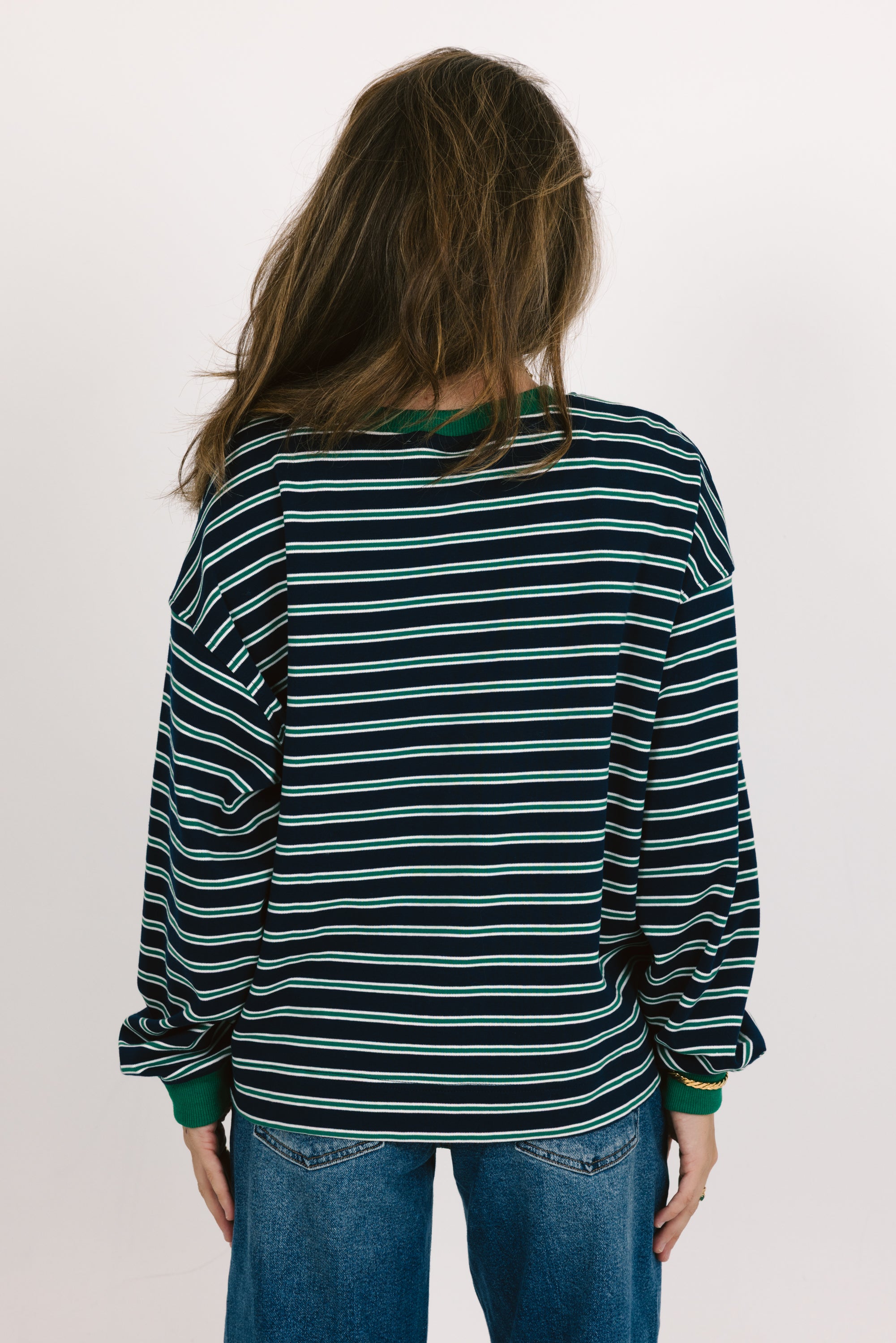 Person wearing a striped shirt with a plain background