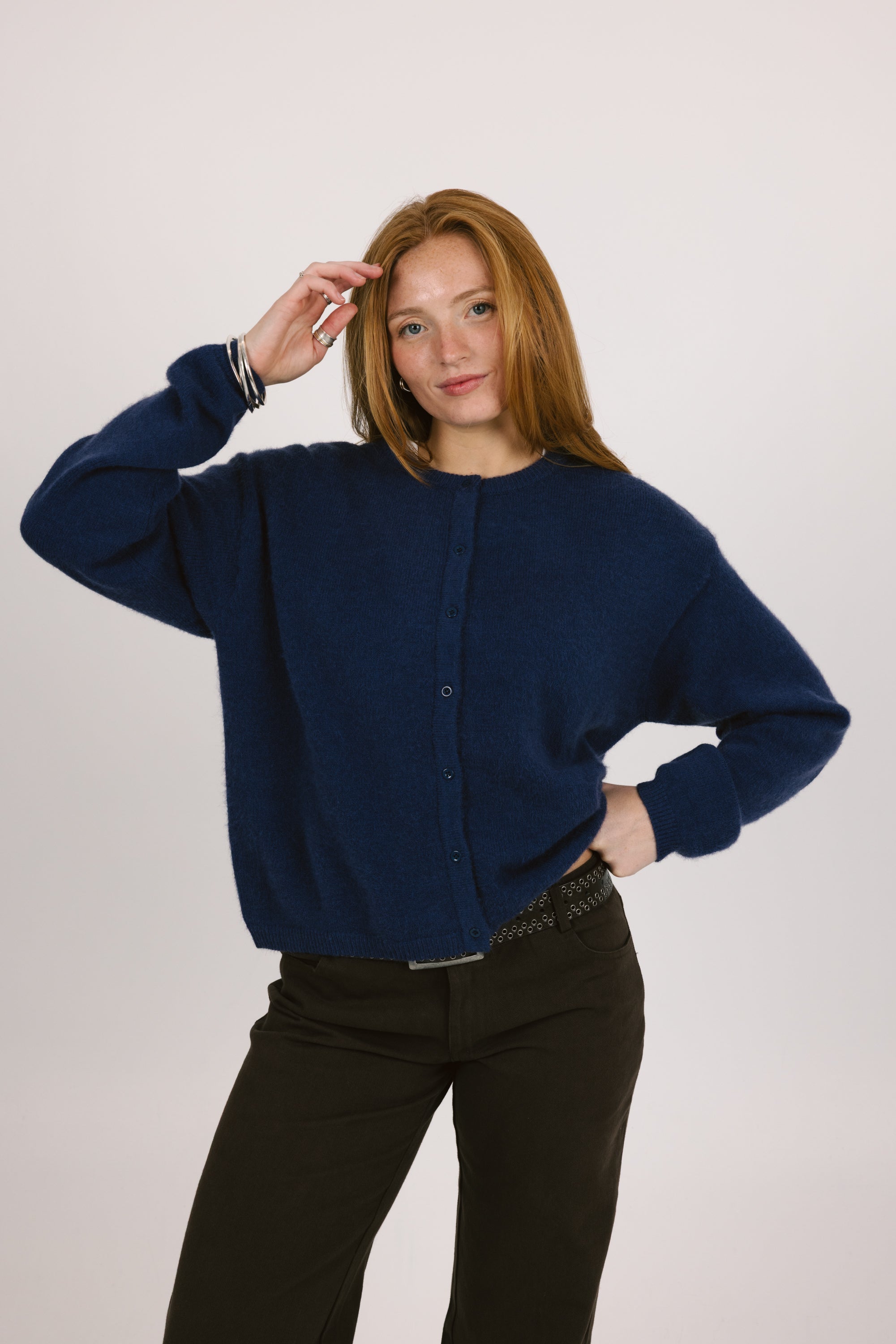 Woman wearing a navy blue cardigan against a plain background