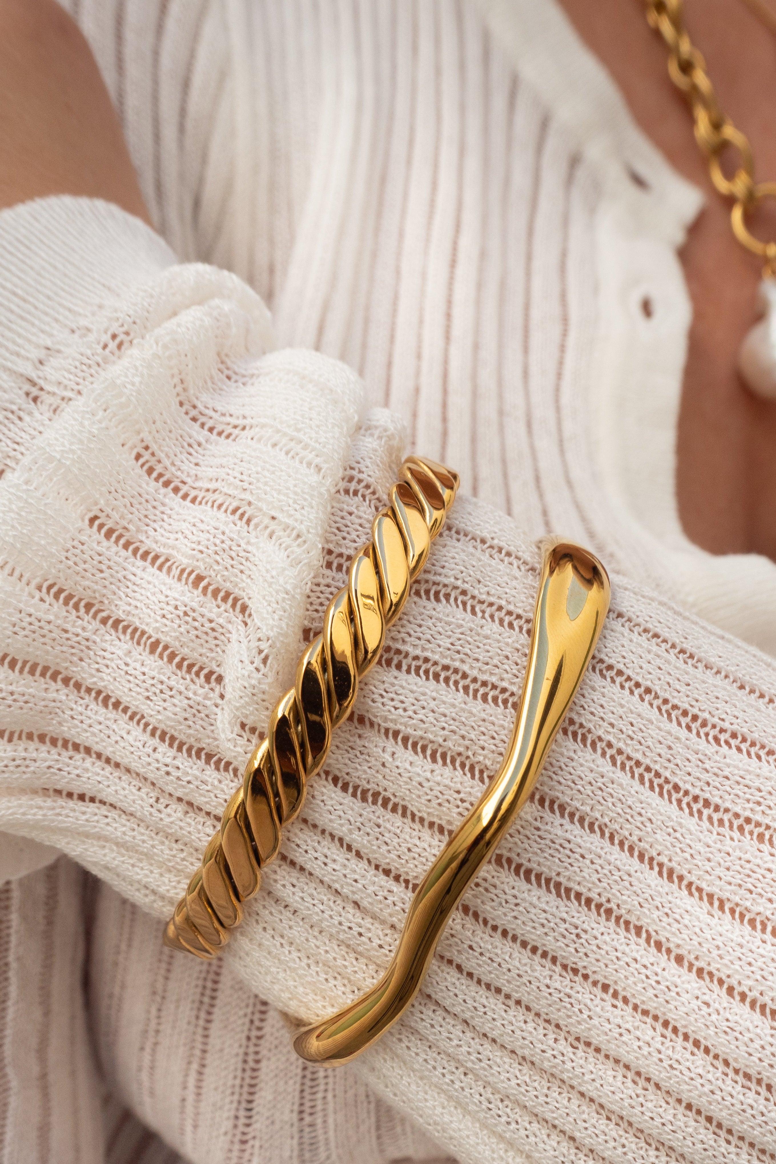 Gold bracelet on a wrist with a blurred background