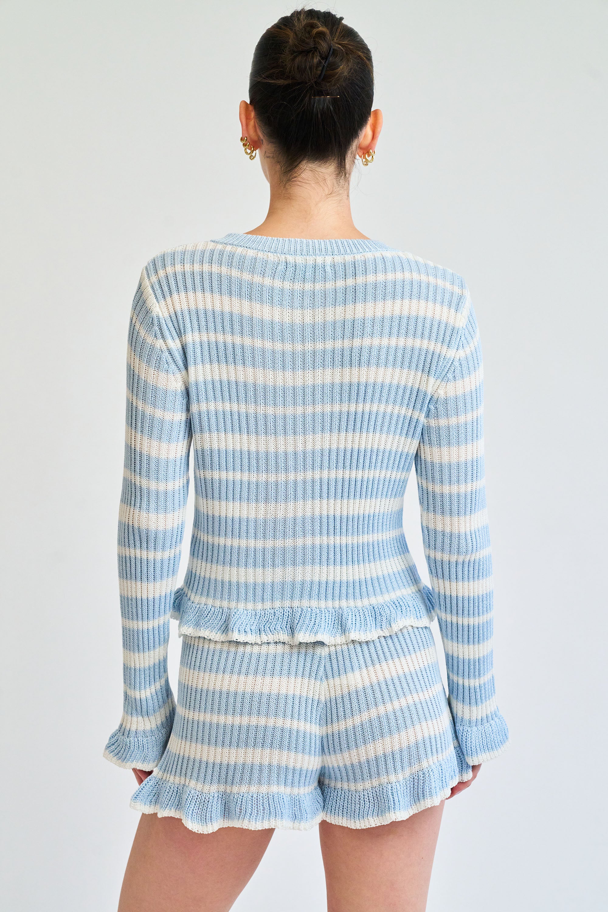 Person wearing a blue and white striped outfit on a plain background