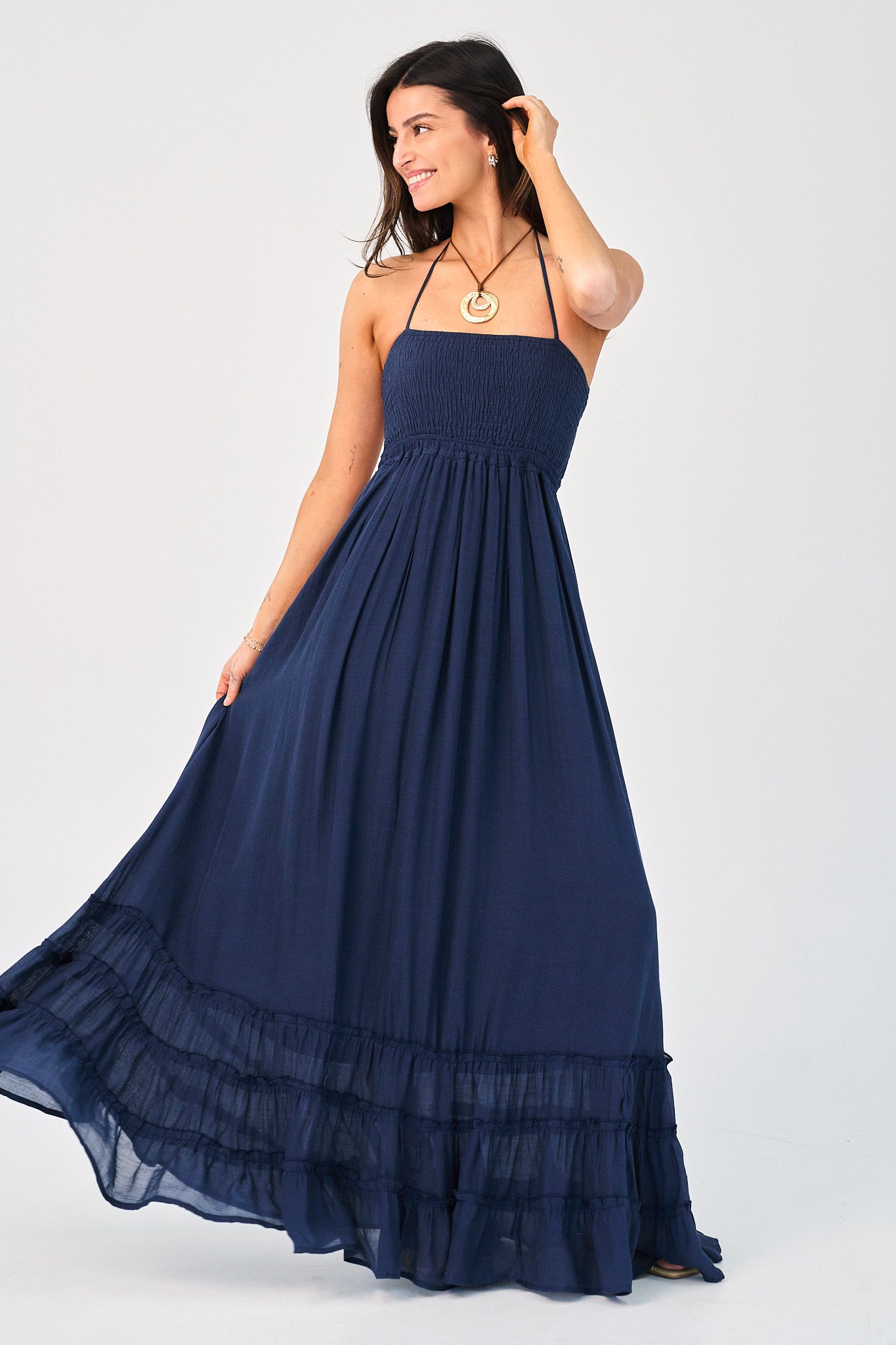 Woman wearing a navy blue maxi dress on a white background