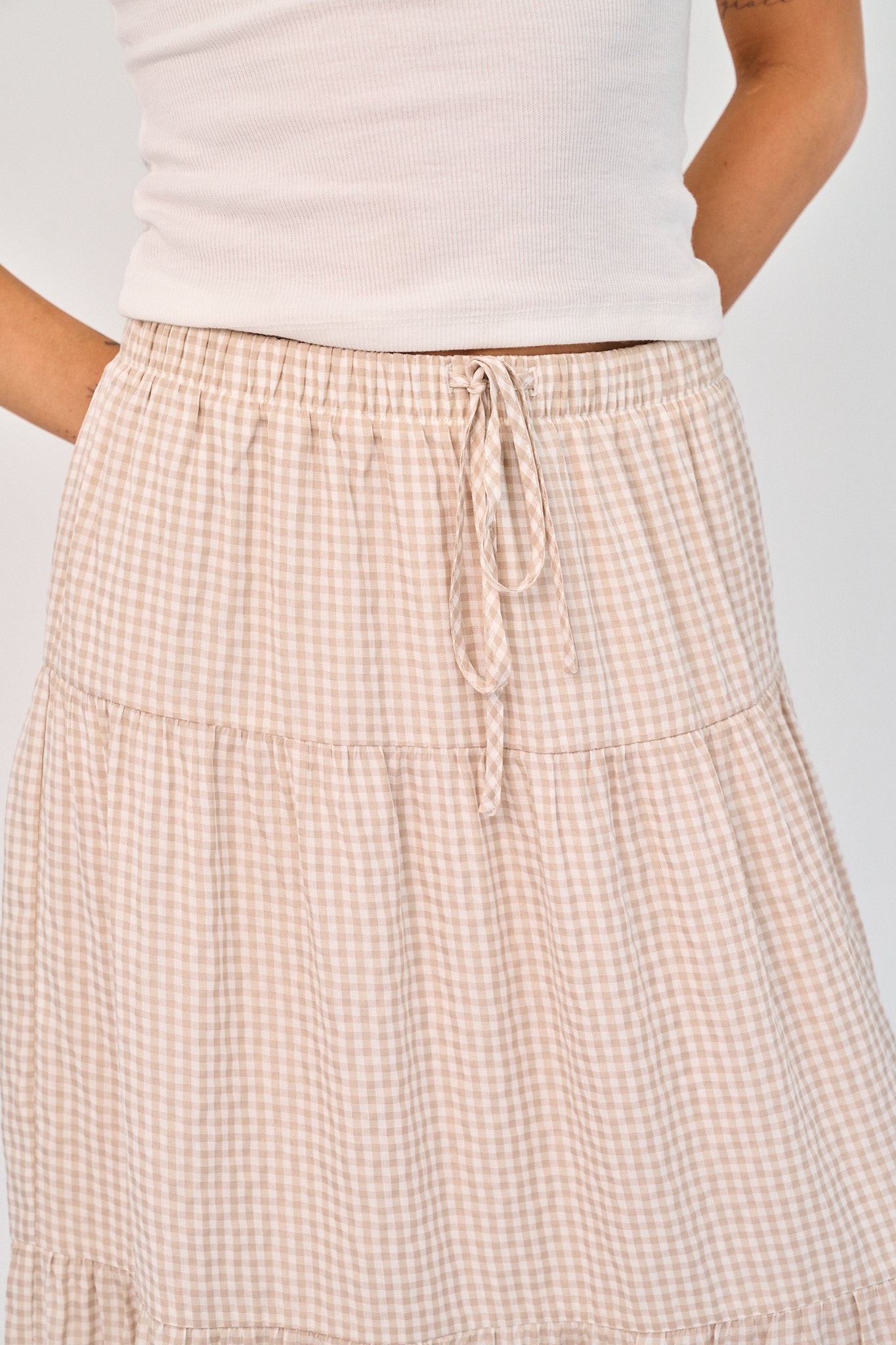 Beige checkered skirt worn by a person on a plain background