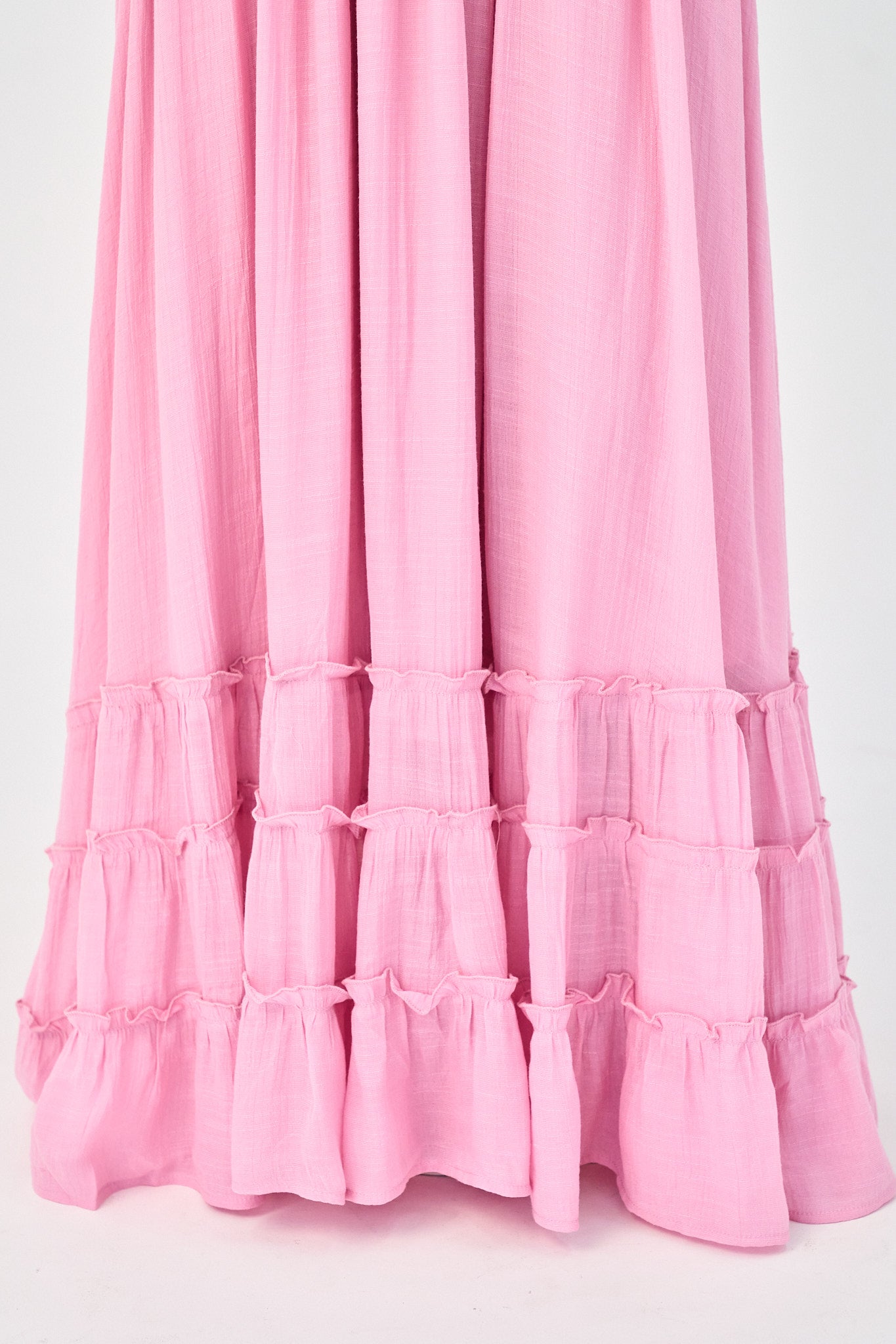 bottom ruffles of a pink maxi dress