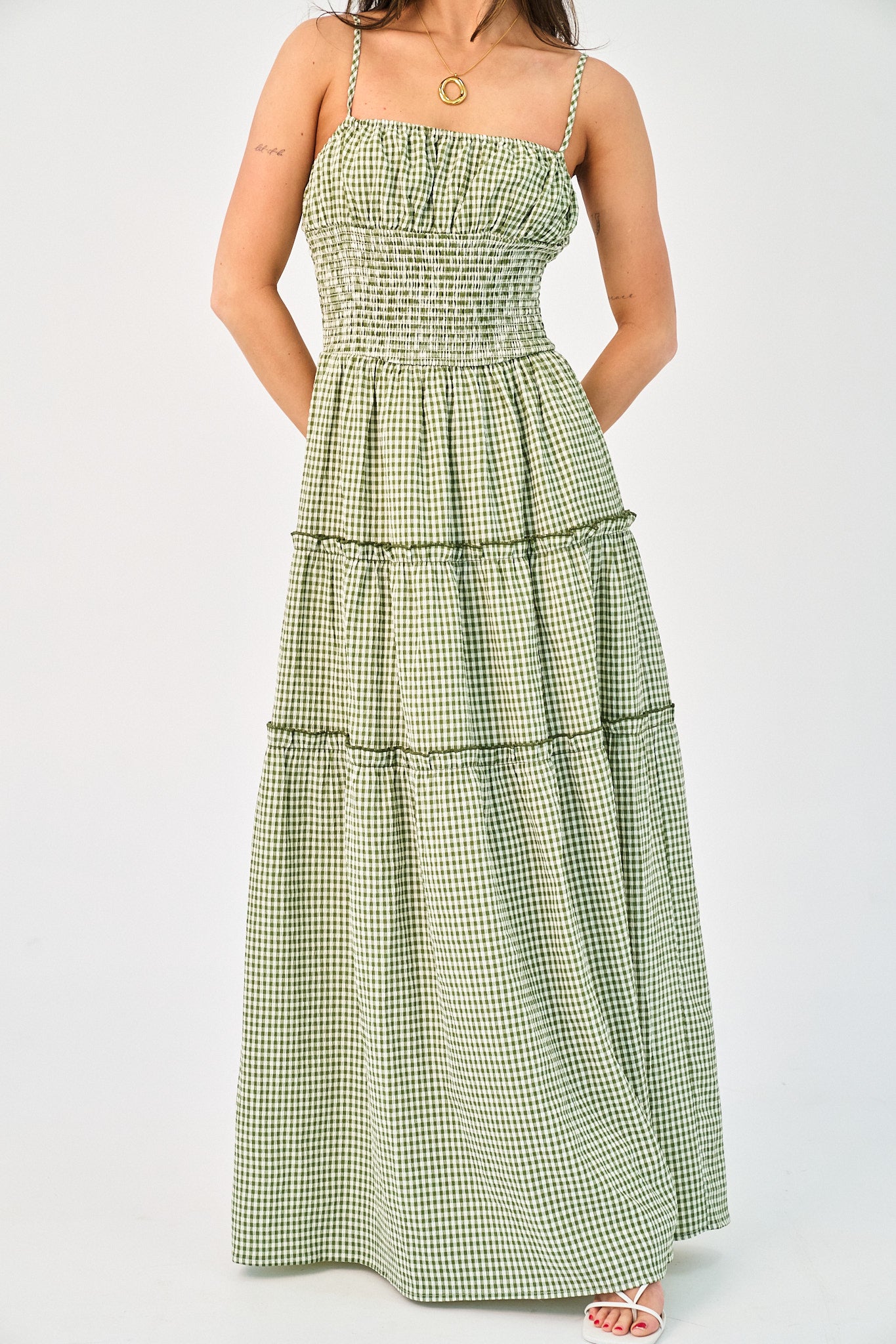 Green checkered dress worn by a person on a white background