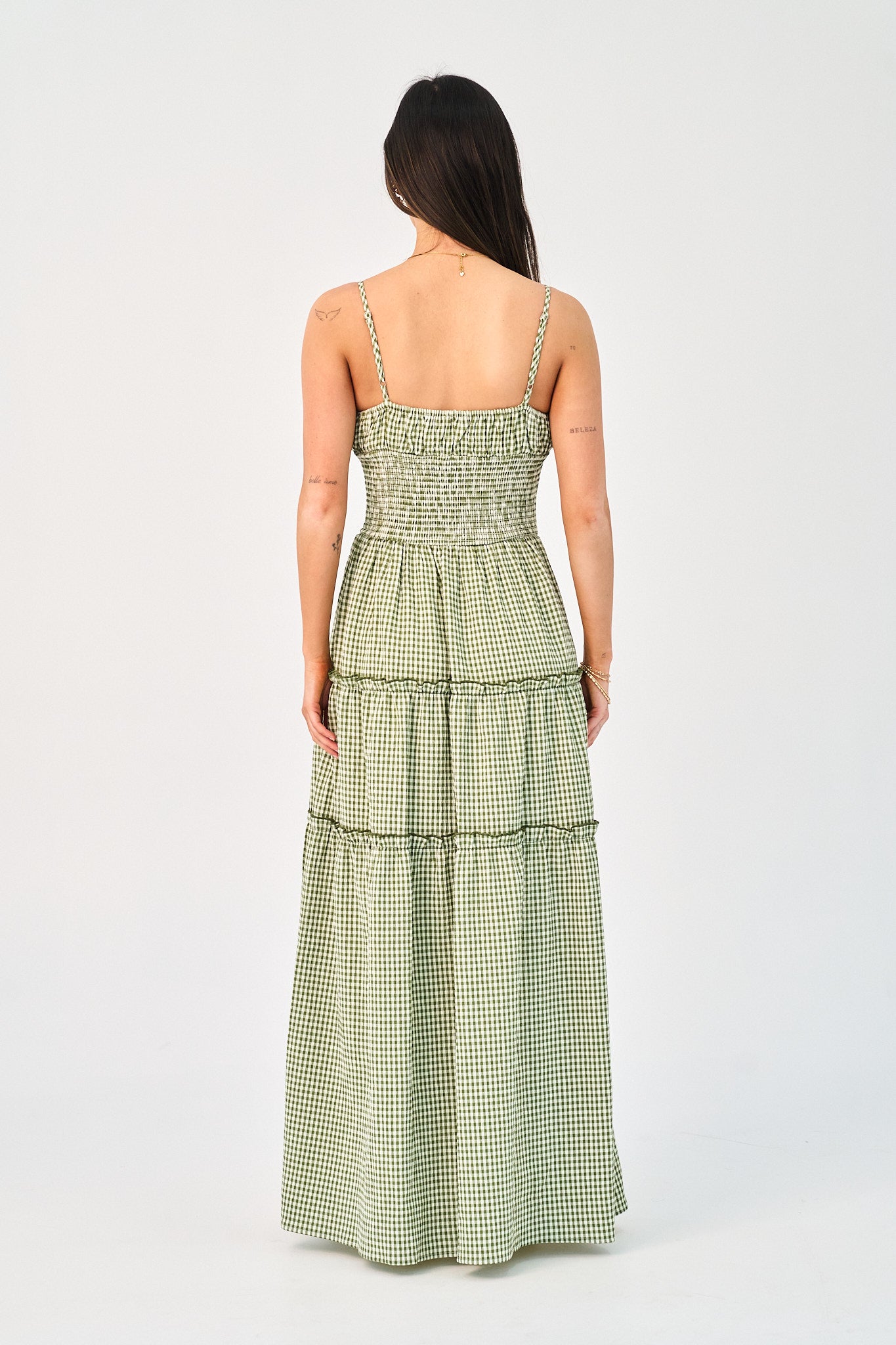 Woman wearing a green checkered dress on a white background