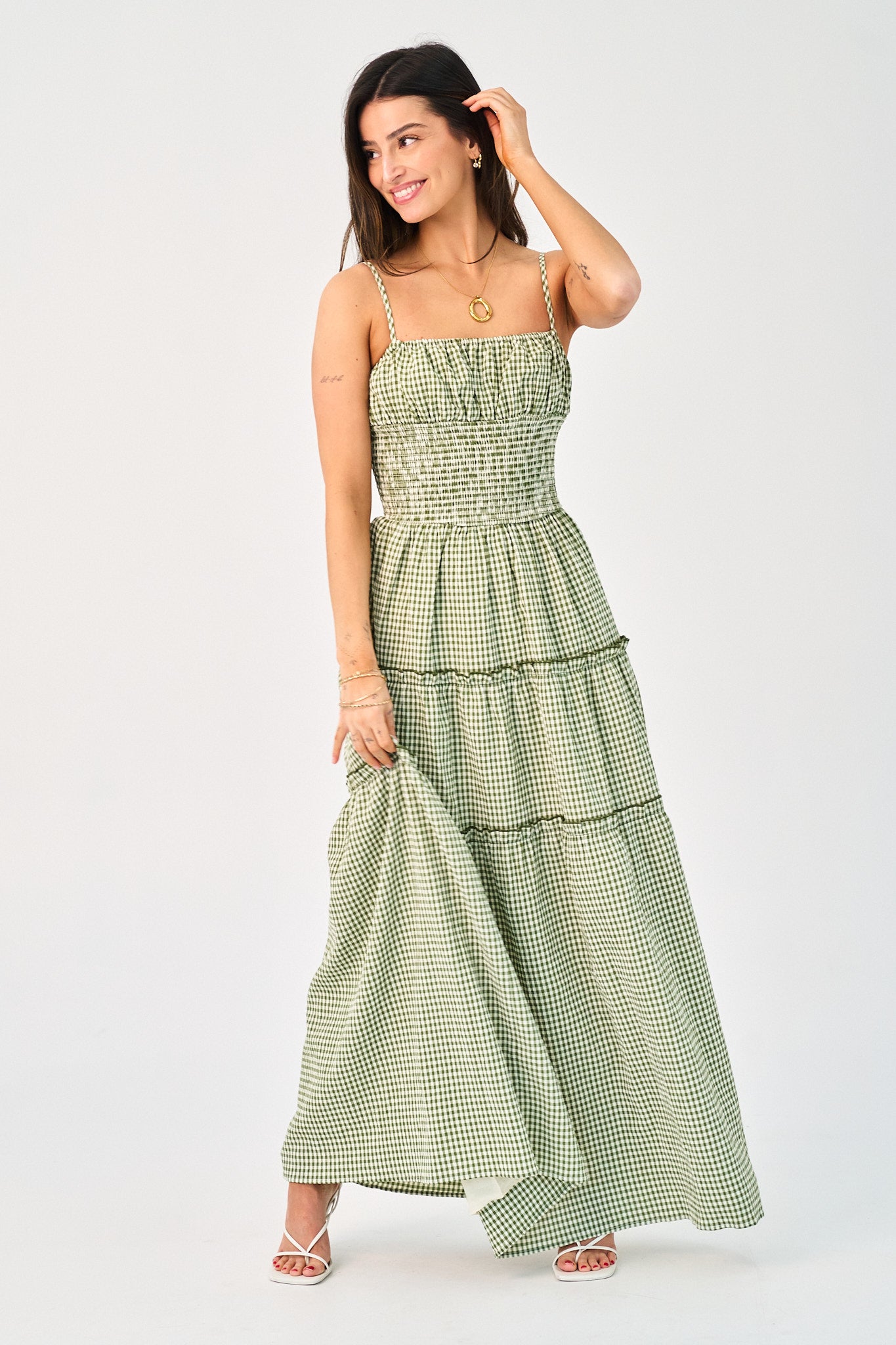 Woman wearing a green checkered dress on a white background