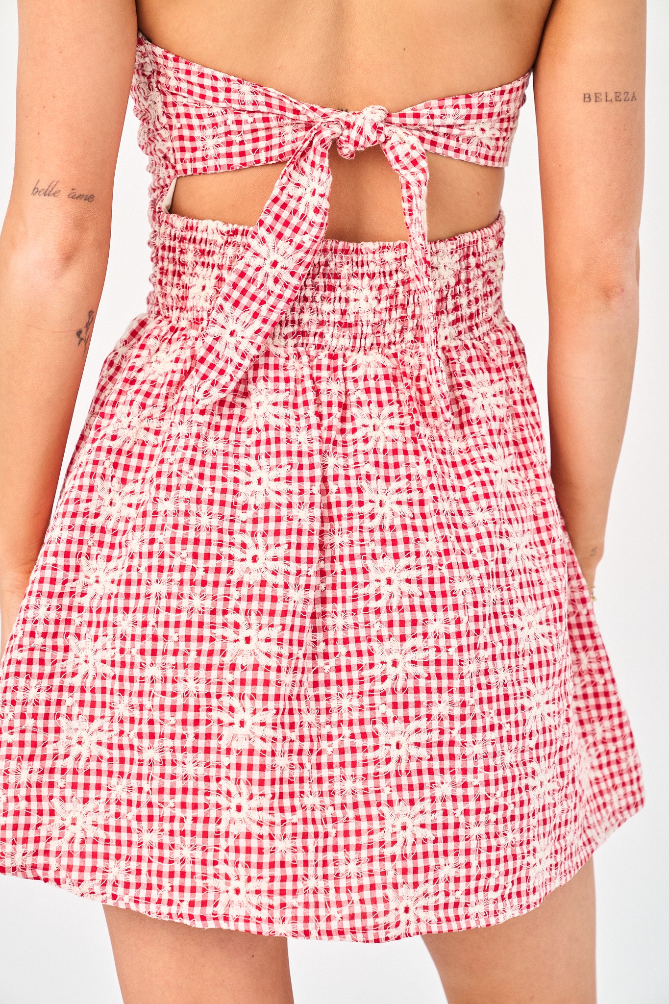 Red and white checkered strapless dress on a plain background