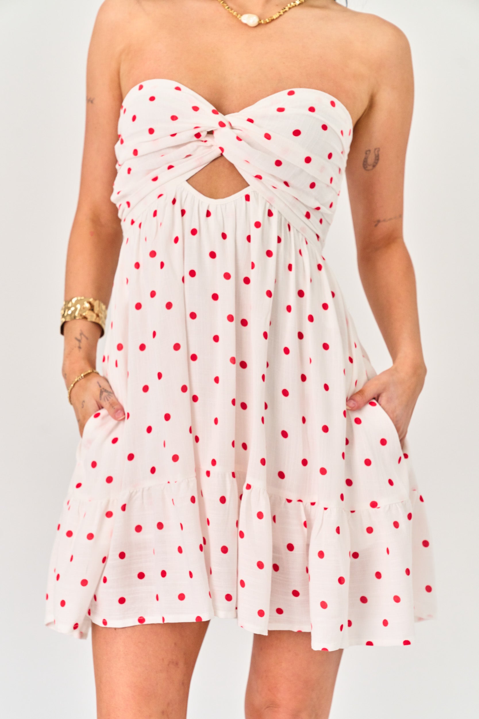 White strapless dress with red polka dots on a plain background