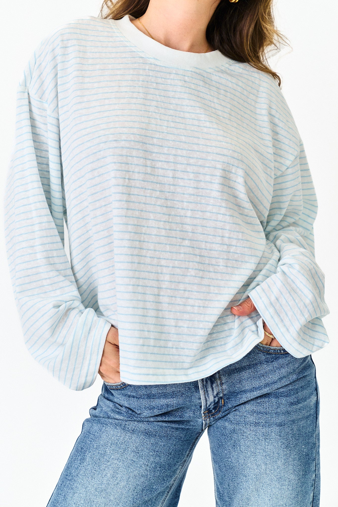Light blue striped sweater worn by a person on a white background
